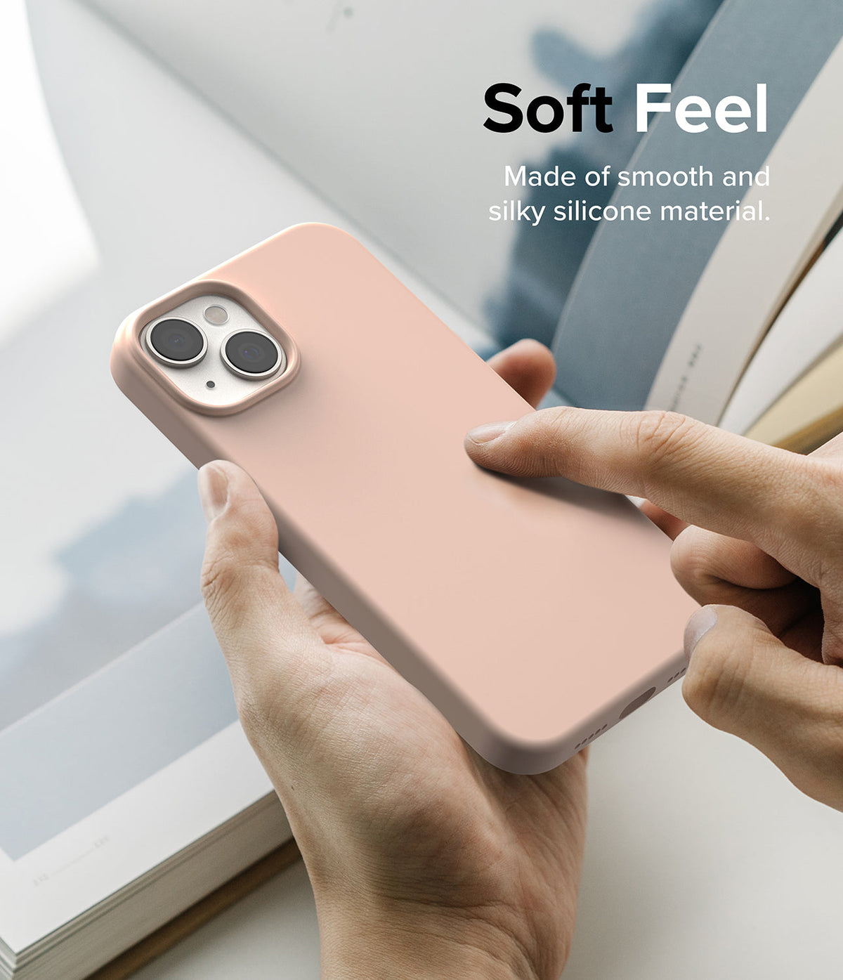 iPhone 14 Case | Silicone - Hand holding a smooth, light pink silicone iPhone 14 case with text reading Soft Feel.