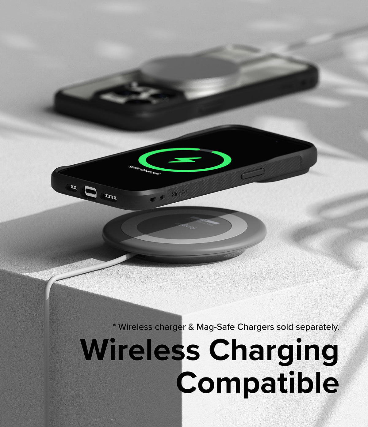 iPhone 15 Pro Max Case | Fusion Bold - Black phone case on a wireless charging pad showing a green charging icon.