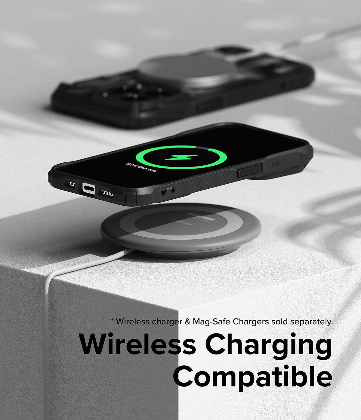 iPhone 15 Pro Max Case | Fusion-X - iPhone 15 Pro Max in a black case wirelessly charging on a pad with a green charging icon.