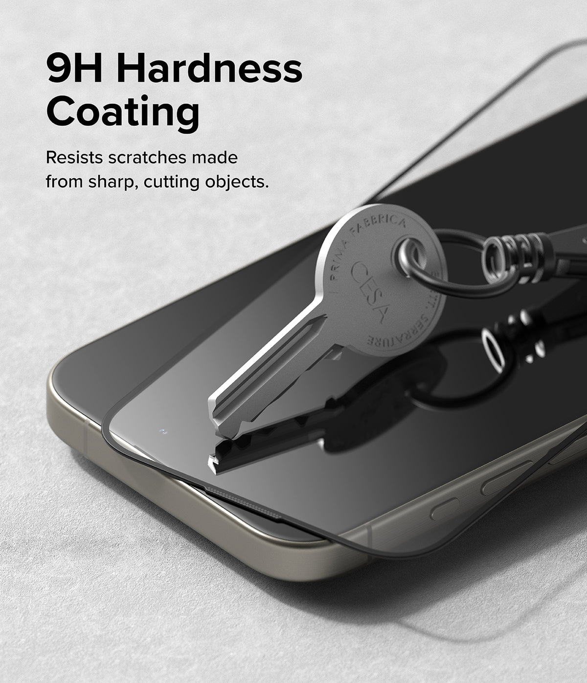 iPhone 15 Pro Max Screen Protector | Easy Slide Tempered Glass - iPhone 15 Pro Max Screen Protector - A metal key pressing against a smartphone screen protector to demonstrate scratch resistance.