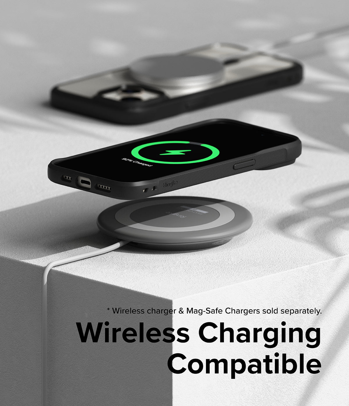 iPhone 15 Plus Case | Fusion Bold Magnetic - A black phone case hovering over a wireless charging pad showing a green charging icon.