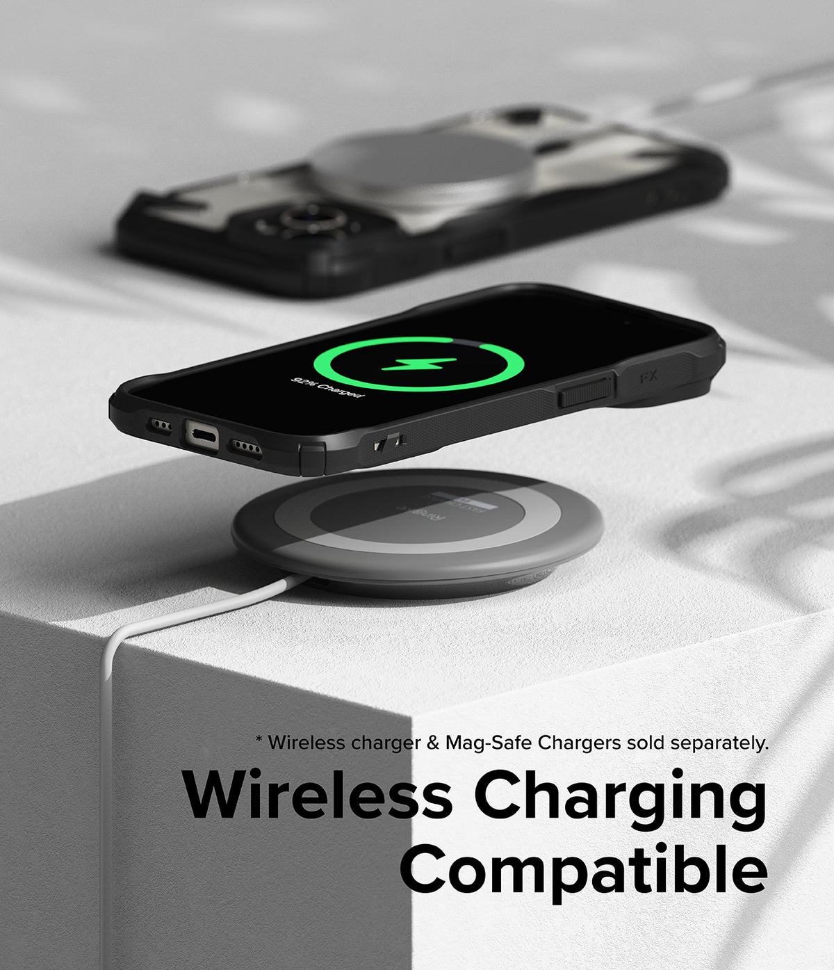 iPhone 15 Plus Case | Fusion-X Magnetic Matte Black - iPhone 15 Plus in a black case wirelessly charging on a pad.