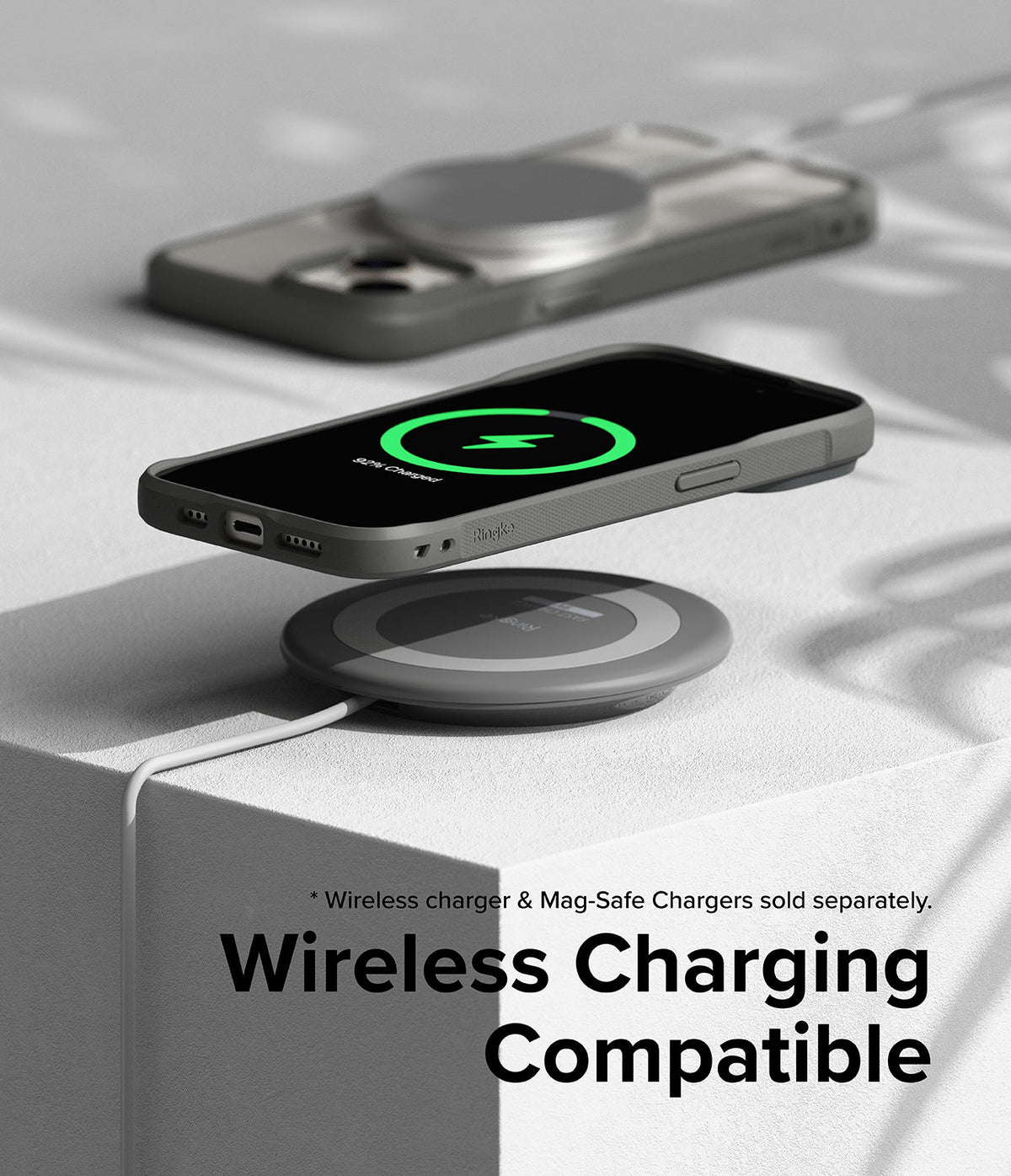 iPhone 15 Case | Fusion Bold - Gray iPhone 15 in a Fusion Bold case hovering over a wireless charging pad showing a green charge icon.