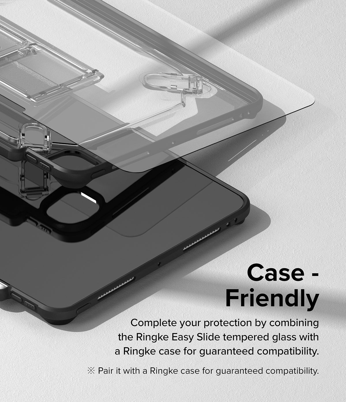Easy Slide Tempered Glass | iPad - A transparent screen protector hovering above a black iPad case on a grey surface.