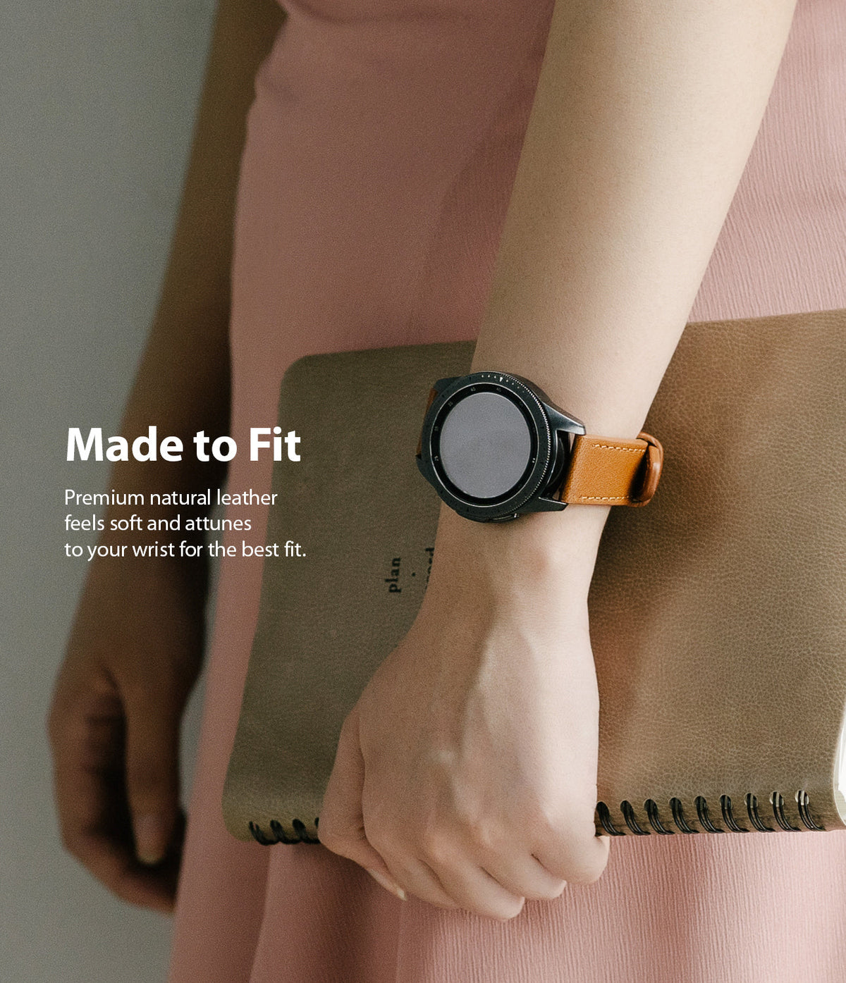 Watch Lug 20mm | Leather One Classic Band - Person wearing a black smartwatch with a tan leather strap holding a notebook.