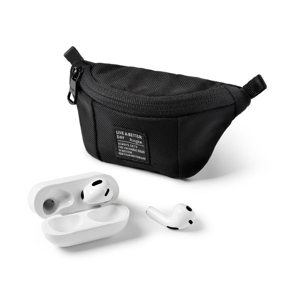 Mini Pouch | Sling Bag - Black textured mini sling bag with a branded patch next to white wireless earbuds and a charging case.