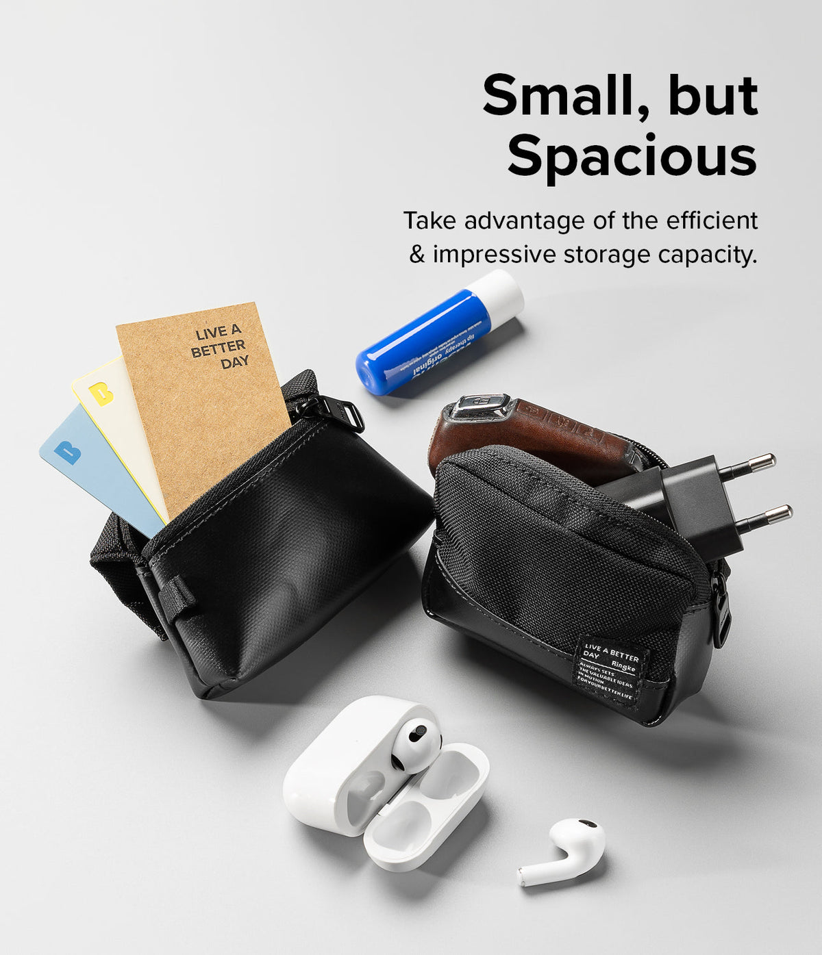 Mini Pouch Tarpaulin | Roll Top - Two black pouches filled with cards, a charger, and earbuds on a light gray background.