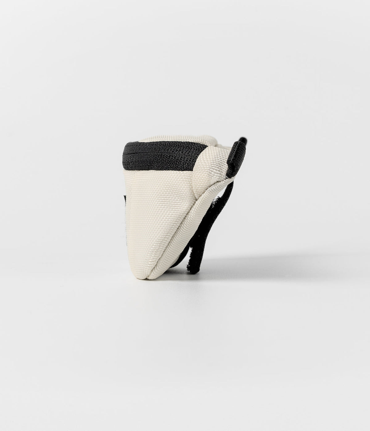 Mini Pouch | Sling Bag - Side profile of a cream-colored mini pouch with a black zipper and strap against a white background.