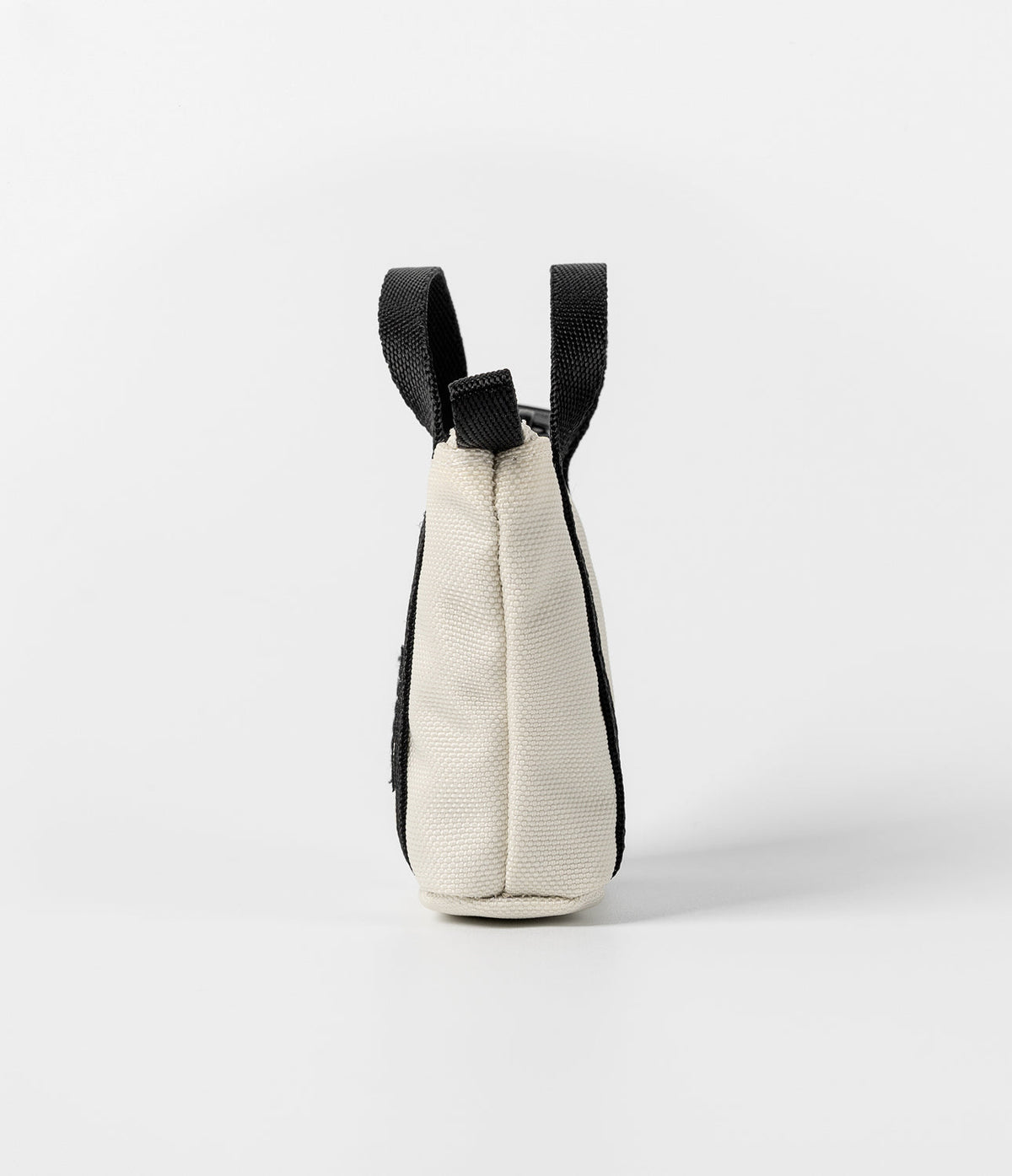 Mini Pouch | Tote Bag - Side view of a small cream canvas pouch with black webbing handles against a white background.
