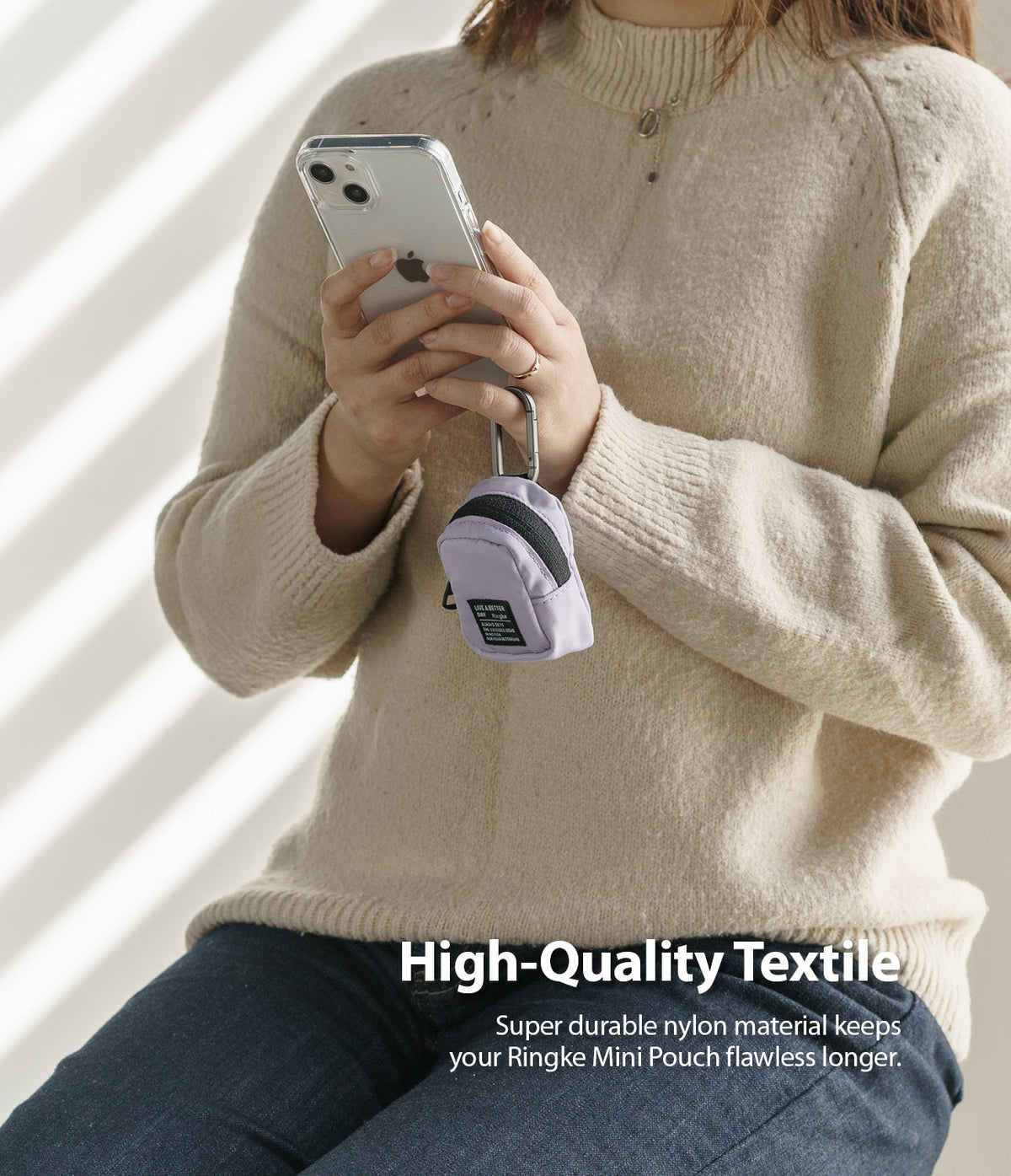 Mini Pouch | Block - Person holding a phone with a small purple nylon pouch clipped to it, featuring durable textile.