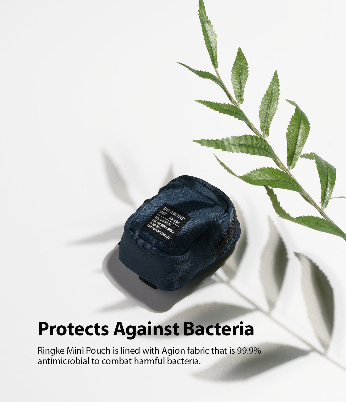Mini Pouch | Block - Navy blue mini pouch with a branded label next to a green leaf on a white background.