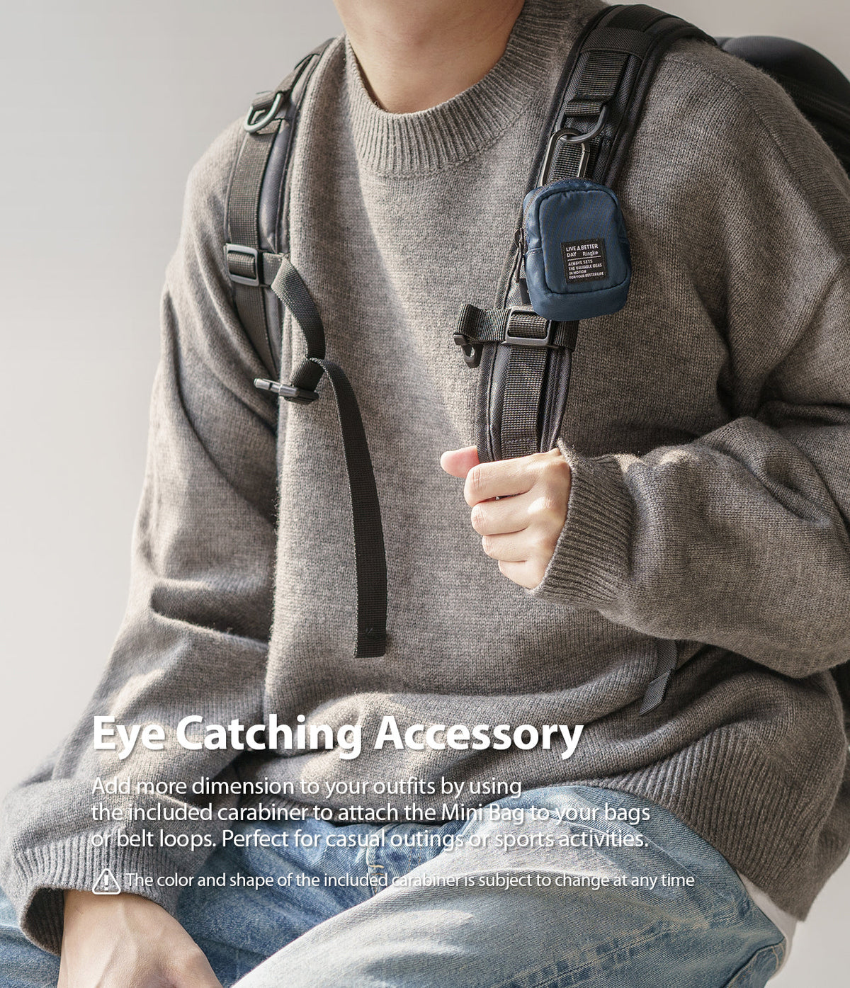 Mini Pouch | Block - A small navy blue pouch clipped to a backpack strap, worn by a person in a grey sweater and jeans.