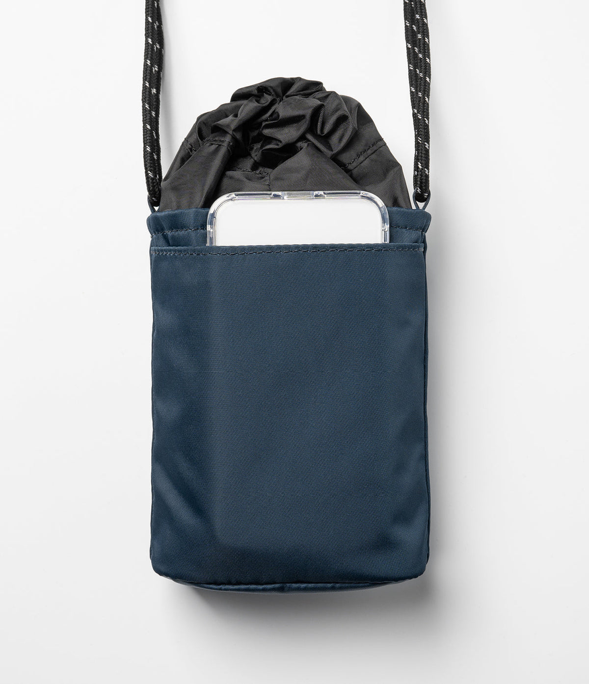 Mini Cross Bag | Bucket Bag - Navy blue bucket bag with a drawstring top and an exterior pocket holding a smartphone.