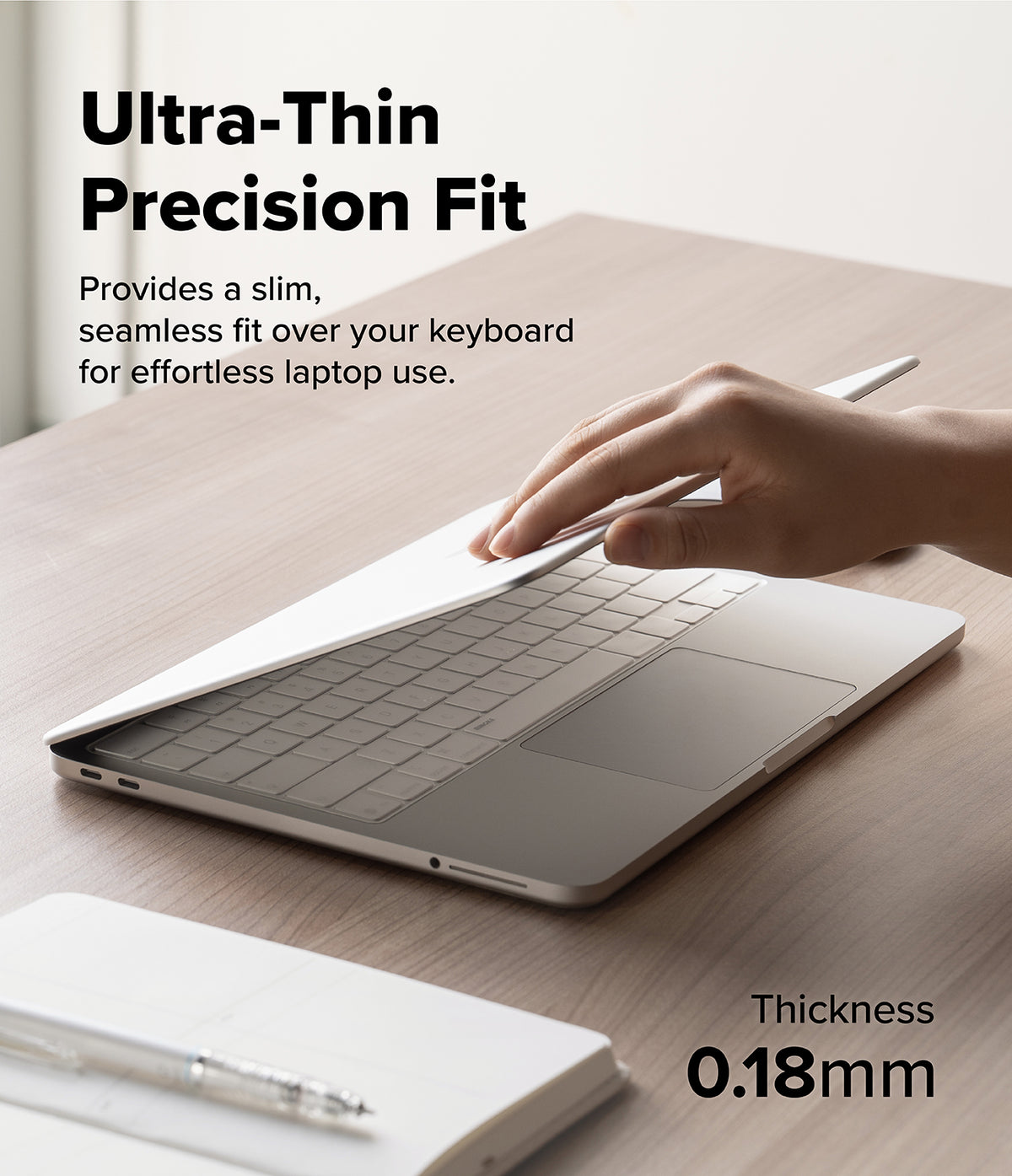 MacBook Neo Case + Protector - A hand is shown pressing down on a slim silver laptop skin or cover placed over a laptop keyboard on a wooden desk. Text reads 'Ultra-Thin Precision Fit' and 'Provides a slim, seamless fit over your keyboard for effortless laptop use.