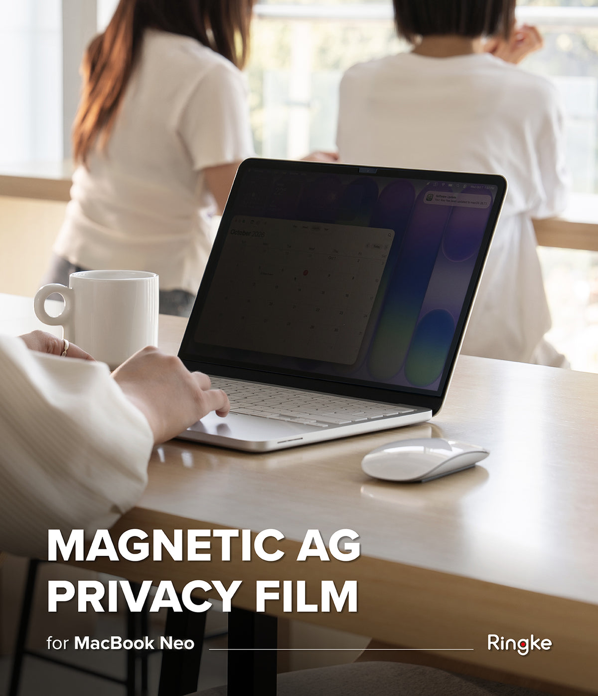 MacBook Neo | Magnetic AG Privacy Film - A person uses a silver MacBook Neo on a wooden desk in a bright office, with two women standing in the background. Large white text at the bottom reads 'MAGNETIC AG PRIVACY FILM for MacBook Neo' with the Ringke brand name.