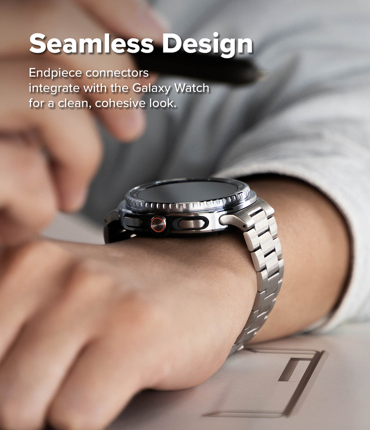 Galaxy Watch 9 / 8 | Metal One Air - Close-up of a smartwatch with a silver metal band worn on a person's wrist, with overlaid text reading 'Seamless Design' and smaller explanatory copy about endpiece connectors.