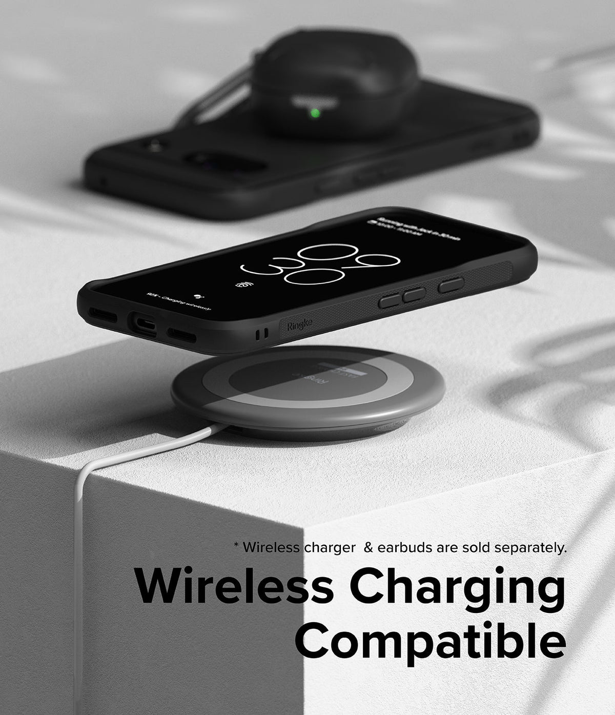 Google Pixel 8a Case | Onyx - Black phone in Onyx case hovering over a wireless charging pad on a white surface.