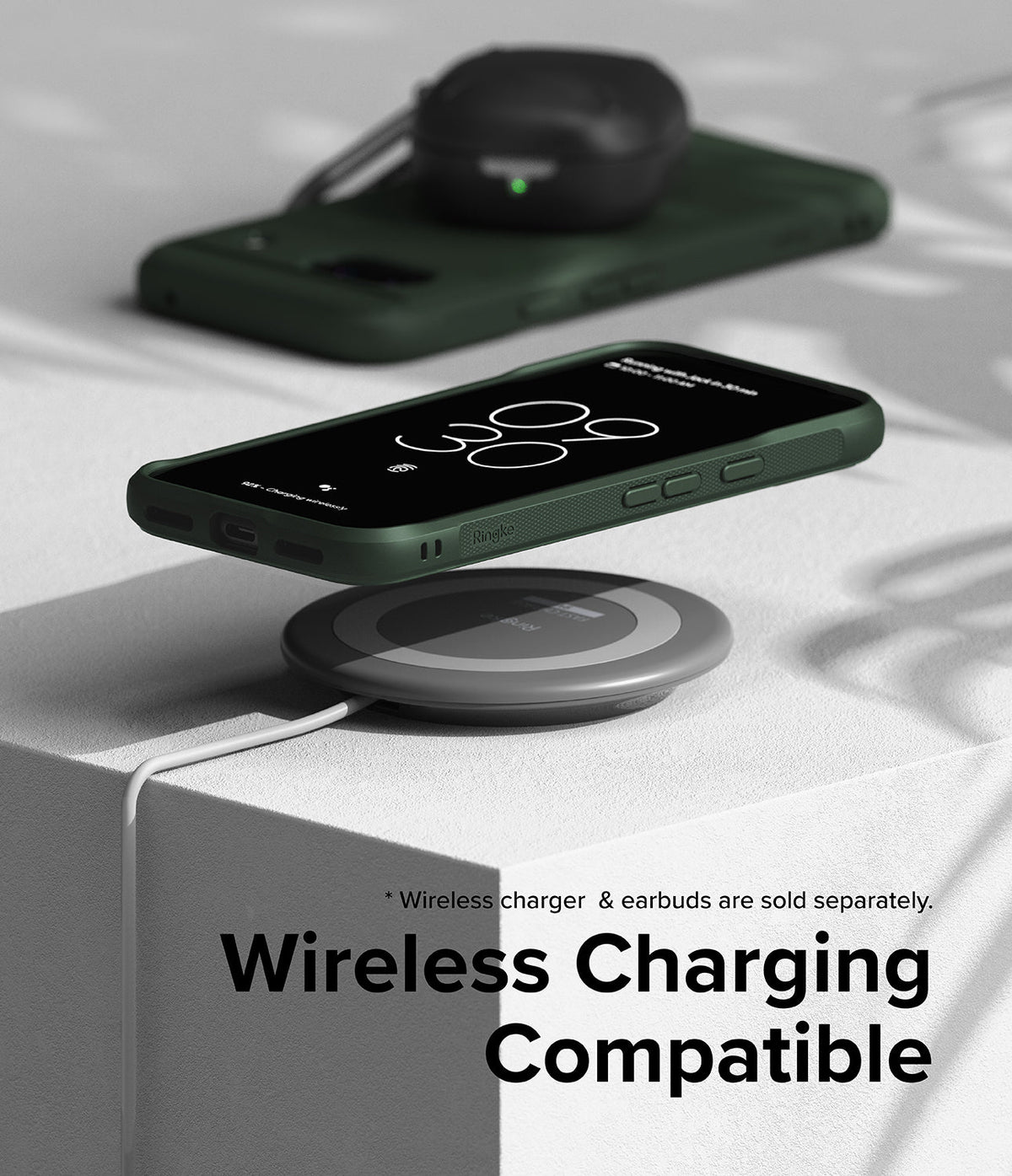 Google Pixel 8a Case | Onyx - Onyx phone case on a smartphone wirelessly charging on a circular pad with earbuds nearby.