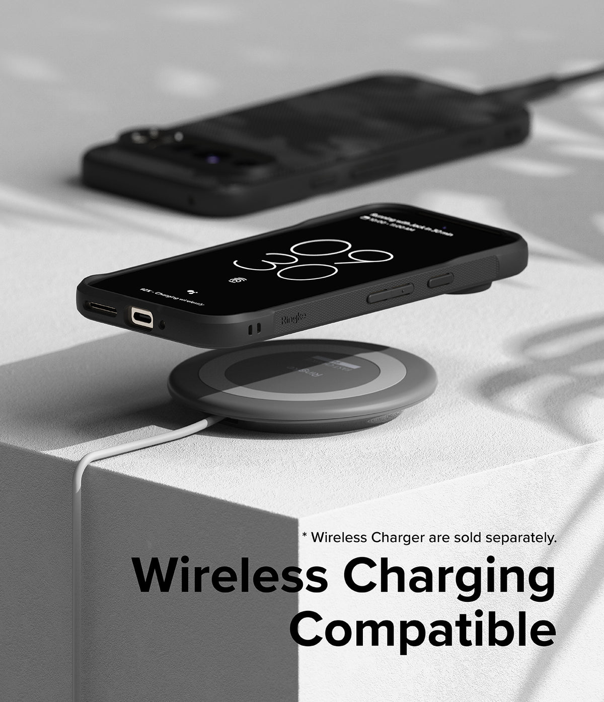 Google Pixel 9 Pro Case | Onyx - A black phone case on a wireless charging pad with a second phone in the background.