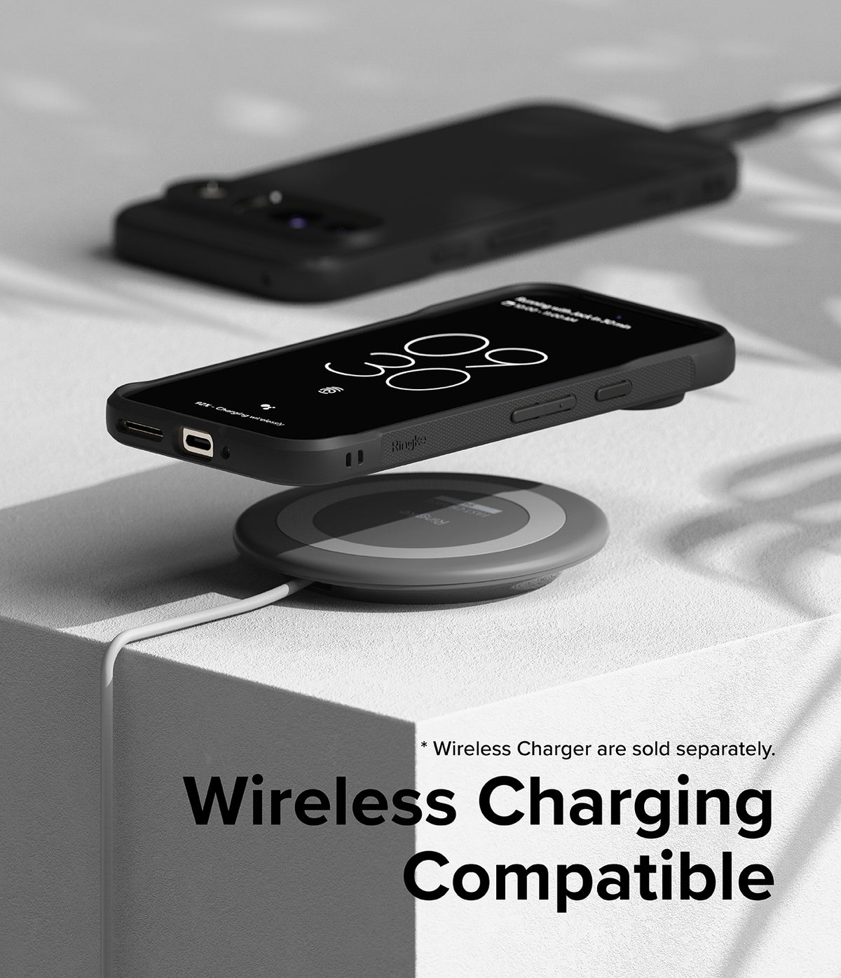 Google Pixel 9 Case | Onyx - Black phone in a protective case hovering over a wireless charging pad on a white block.