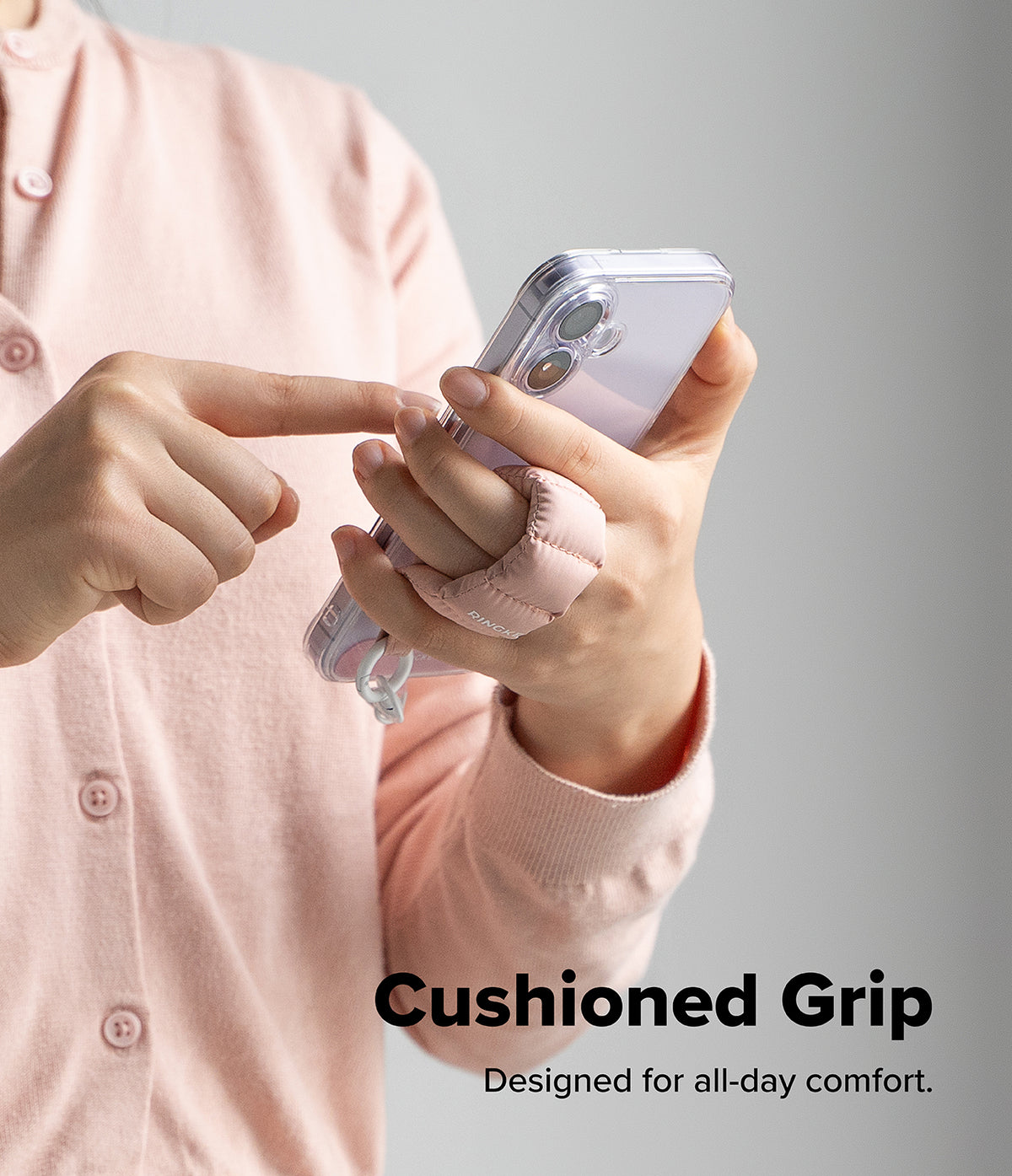 Holder Link Puffer | Finger - Person wearing a pink puffer finger strap on a clear phone case for a cushioned grip.