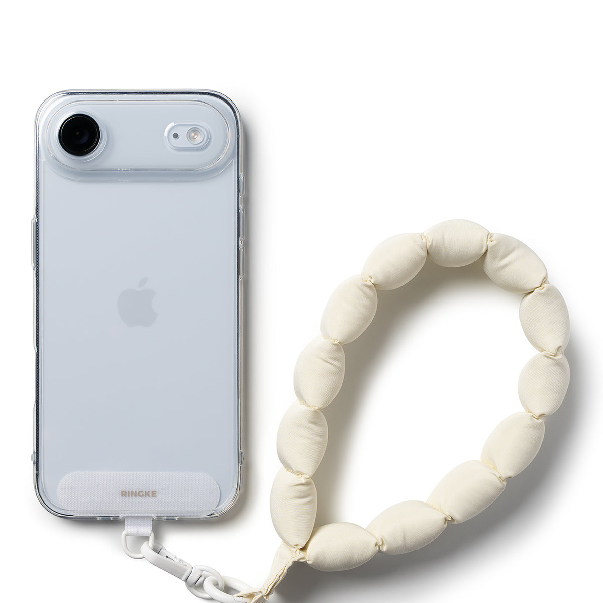 Holder Link Puffer | Hand - A clear phone case attached to a cream-colored, pillowy, bead-style wrist strap.