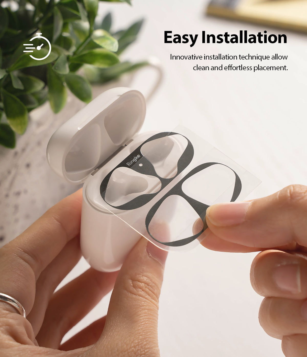 Ringke Airpods 2 / 1 Dust Guard Sticker - Hands applying a black adhesive dust guard to an open white AirPods case.