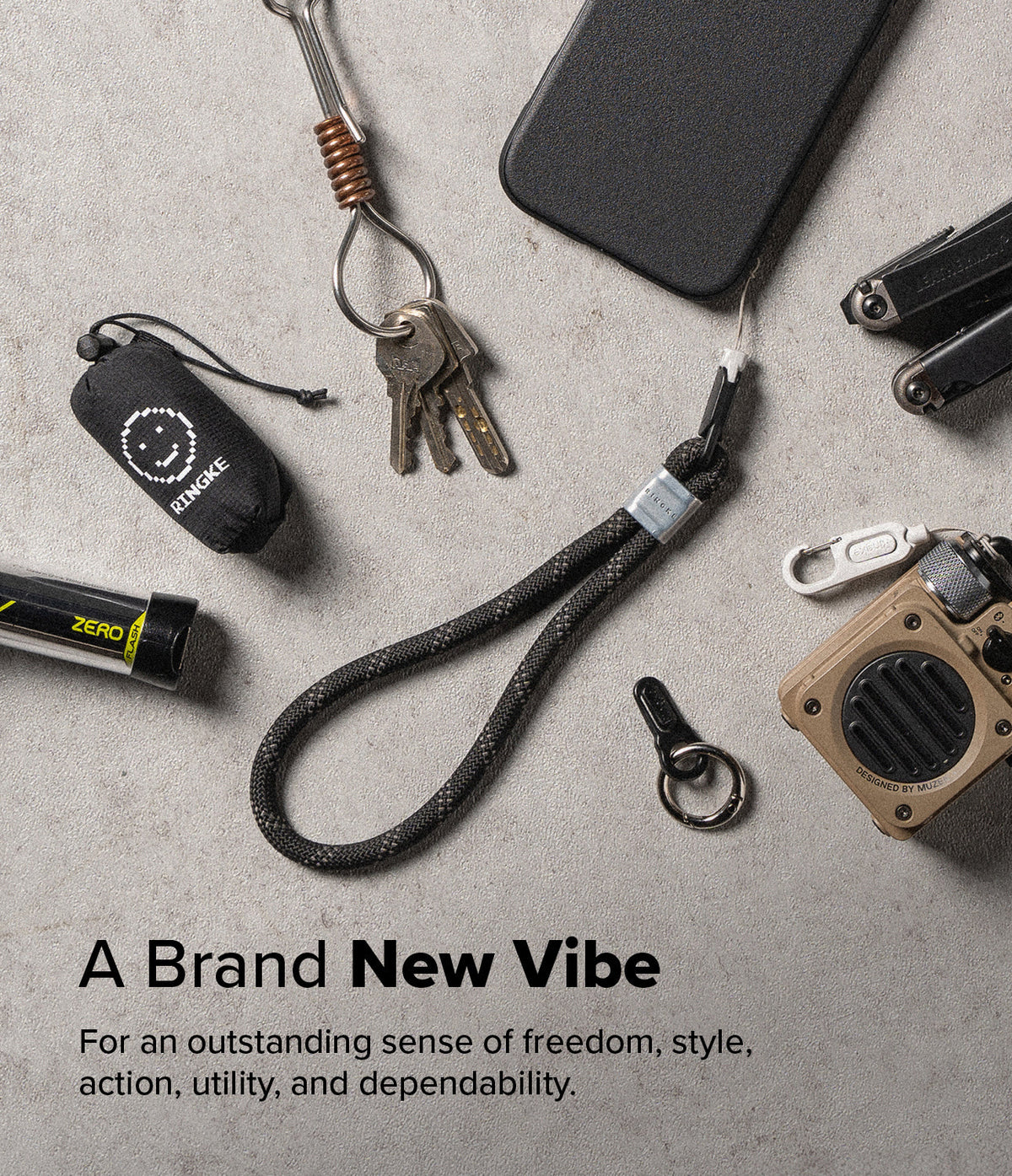 Rope Hand Strap - Black braided rope wrist strap with metal accent, surrounded by EDC gear on a grey textured surface.