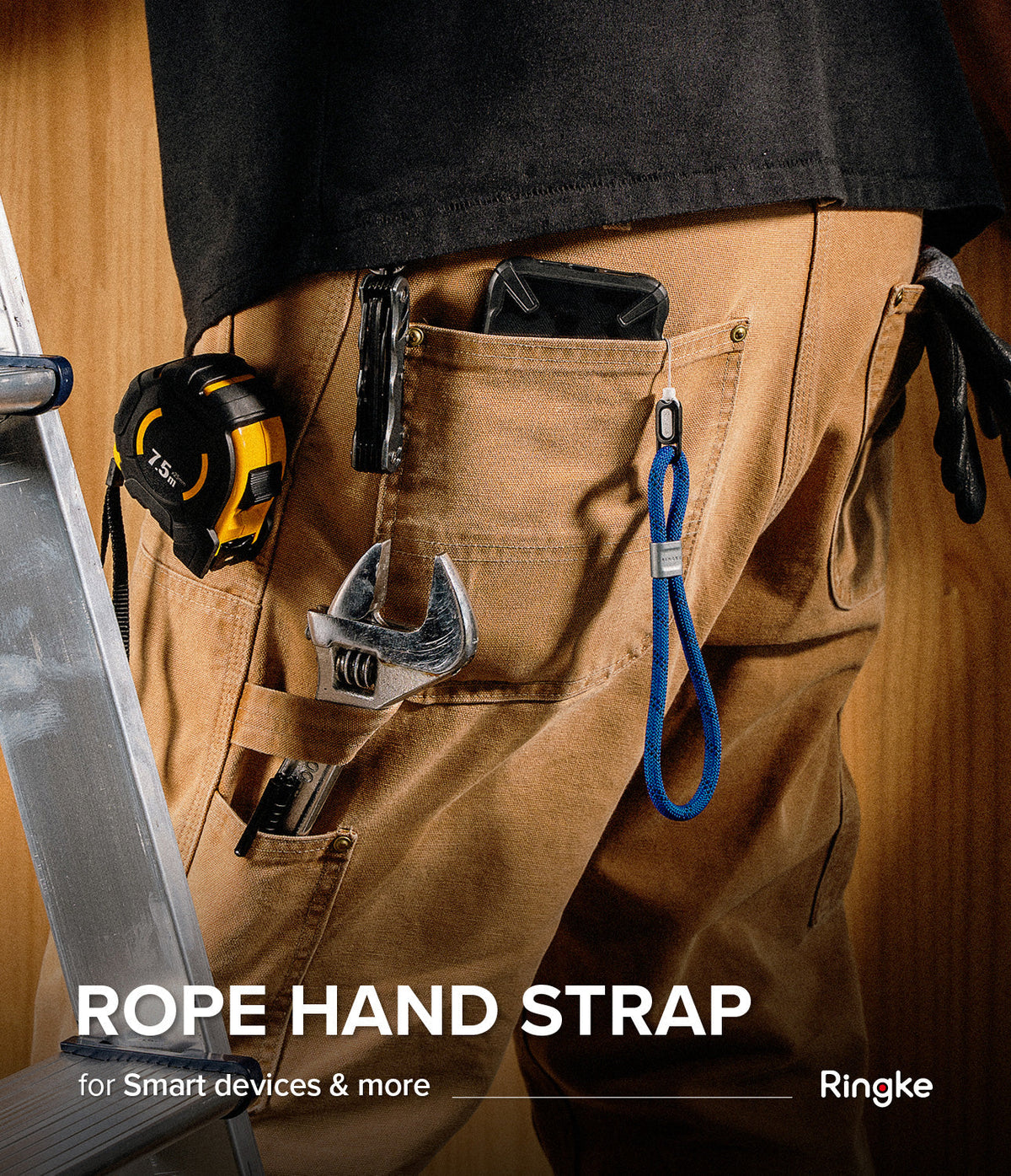 Rope Hand Strap - A blue rope strap attached to a smartphone in a worker's pocket, surrounded by tools on brown work pants.