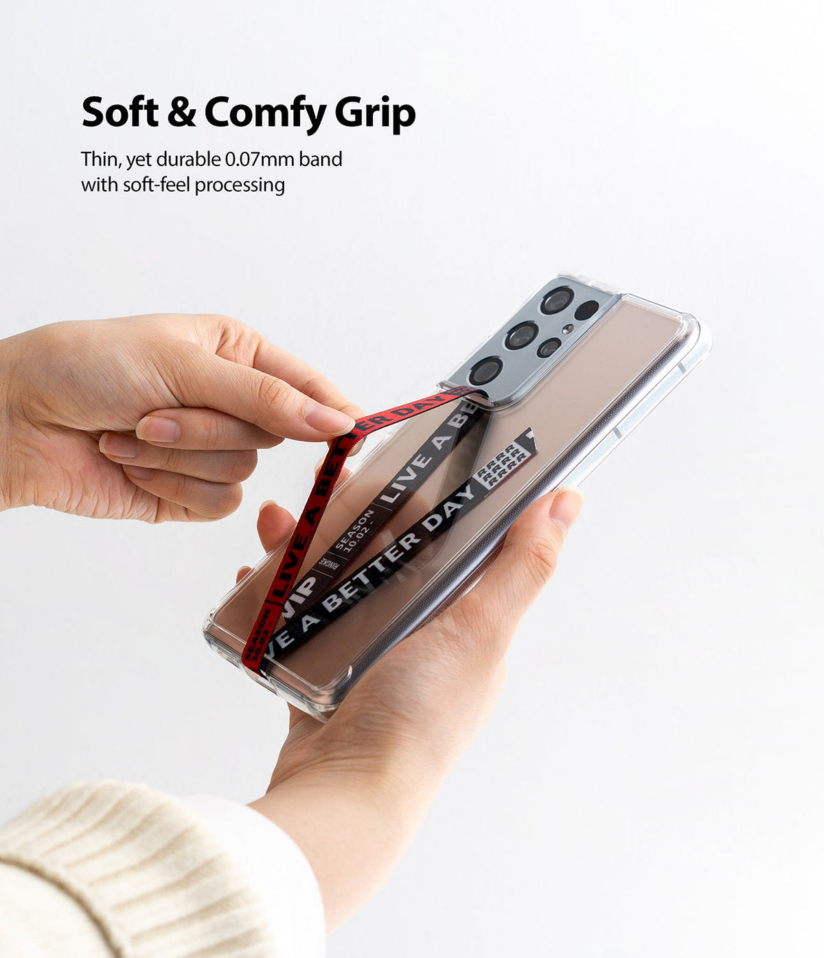 Ringke Strap Band - Hands holding a smartphone with a clear case and a red fabric strap printed with text.
