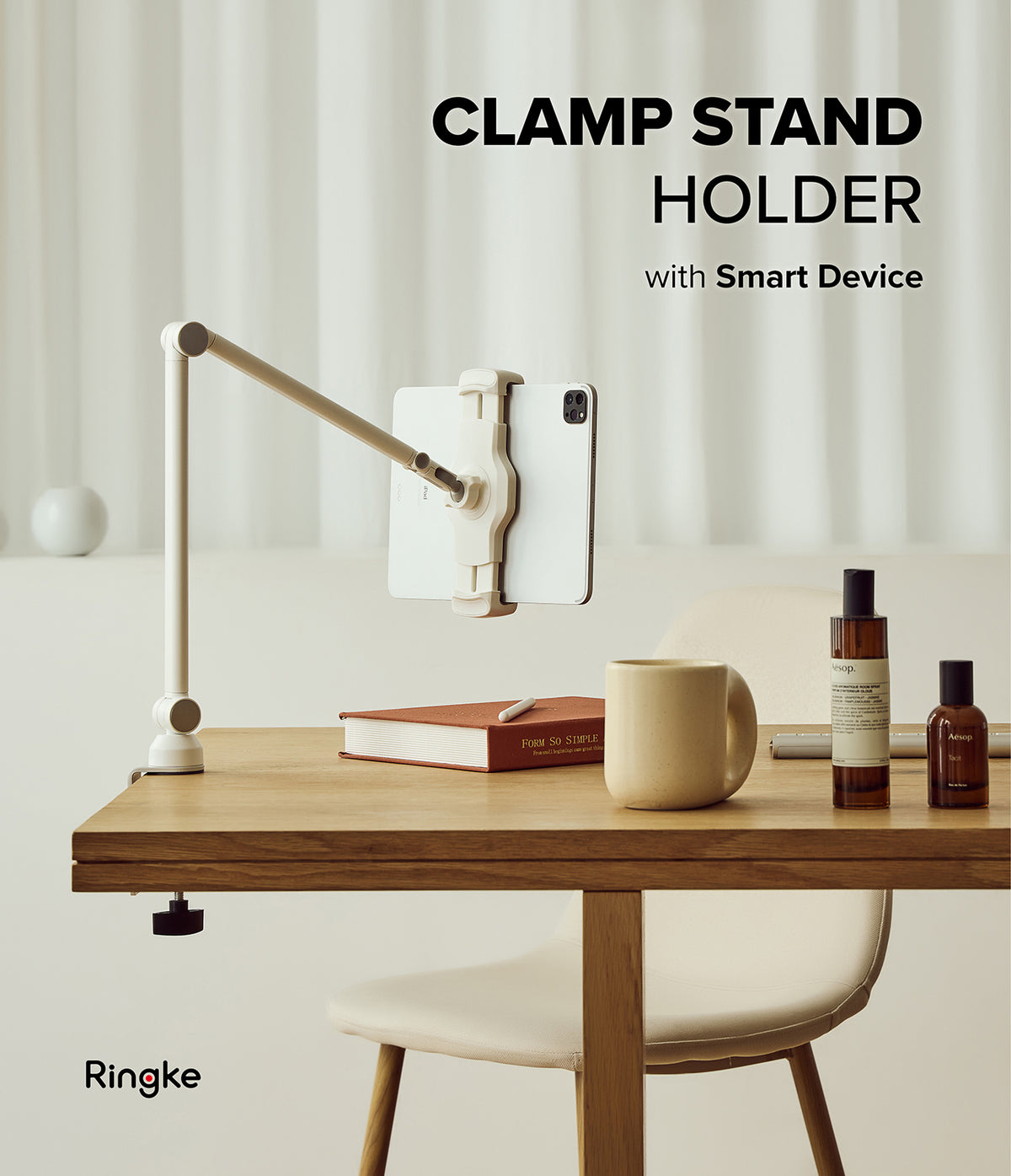 Ringke Clamp Holder - Adjustable desk-mounted tablet stand holding a white tablet on a wooden table with a mug and books.