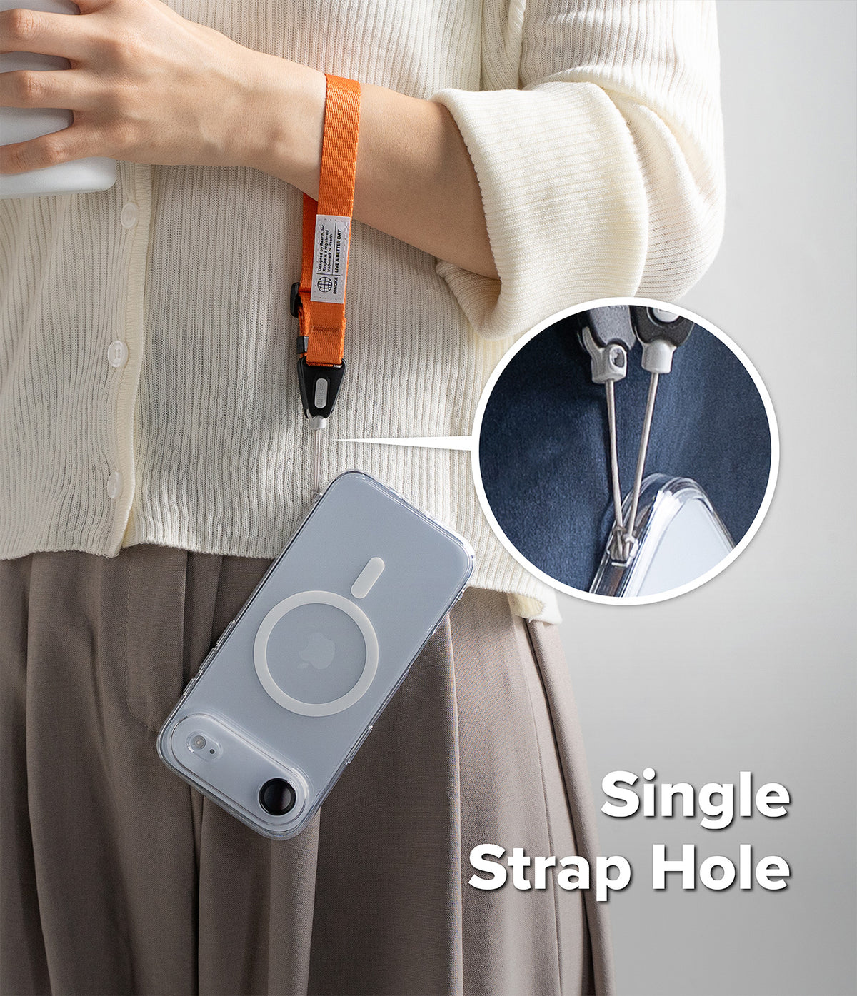 Dual Hand Slim Strap - Orange wrist strap attached to a clear phone case via a single strap hole, with a magnified inset.
