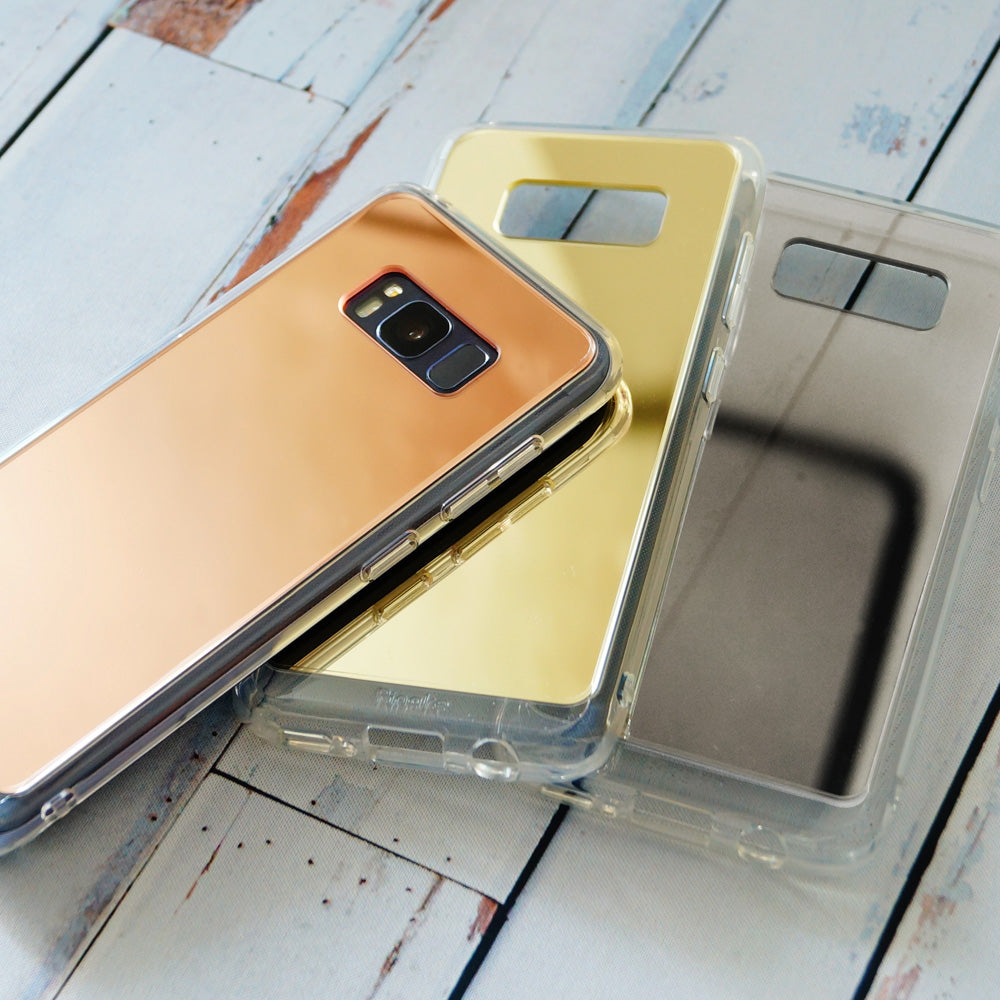 Galaxy S8 Case | Mirror - Three reflective phone cases in rose gold, gold, and silver stacked on a rustic wooden surface.