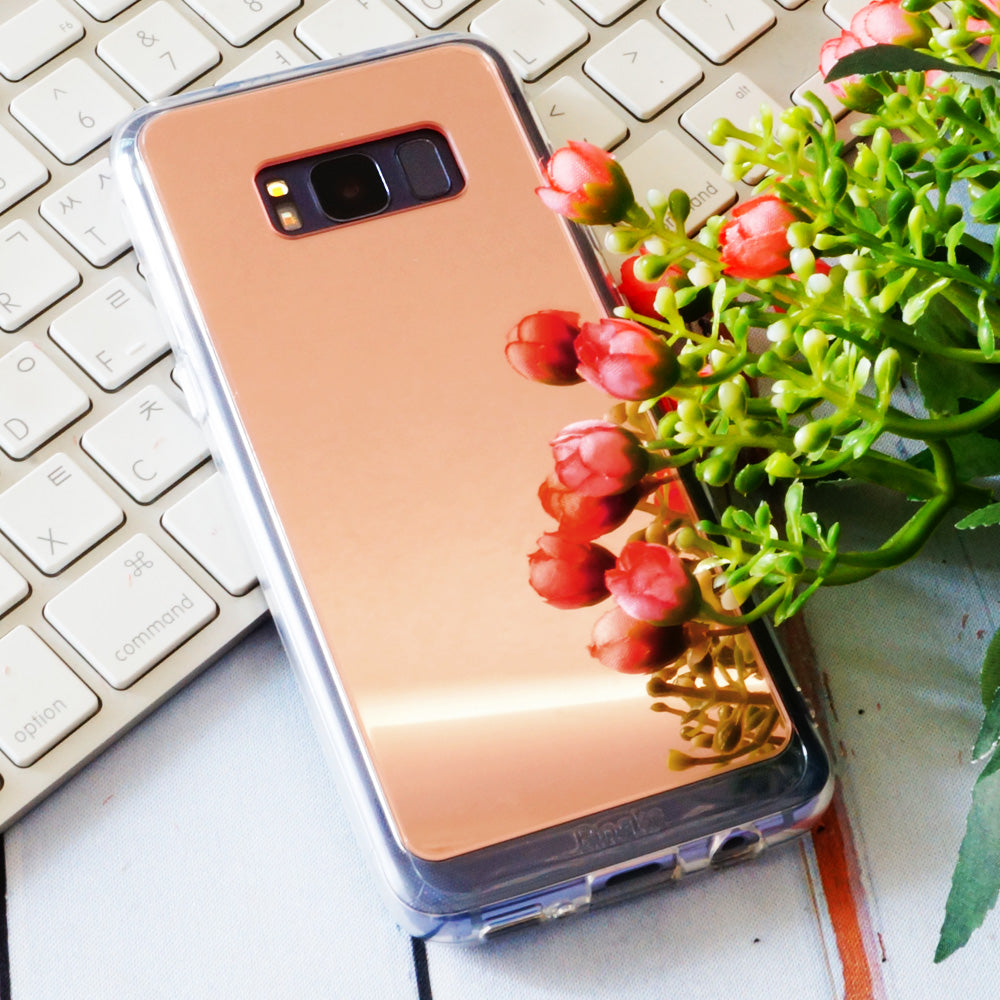 Galaxy S8 Plus Case | Mirror - Rose gold mirrored phone case on a white keyboard with red flowers reflecting on the surface.