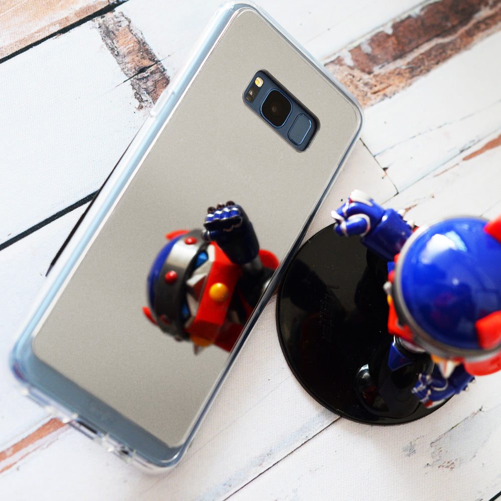 Galaxy S8 Case | Mirror - A reflective phone case on a white wooden surface, mirroring a small blue and red robot figurine.