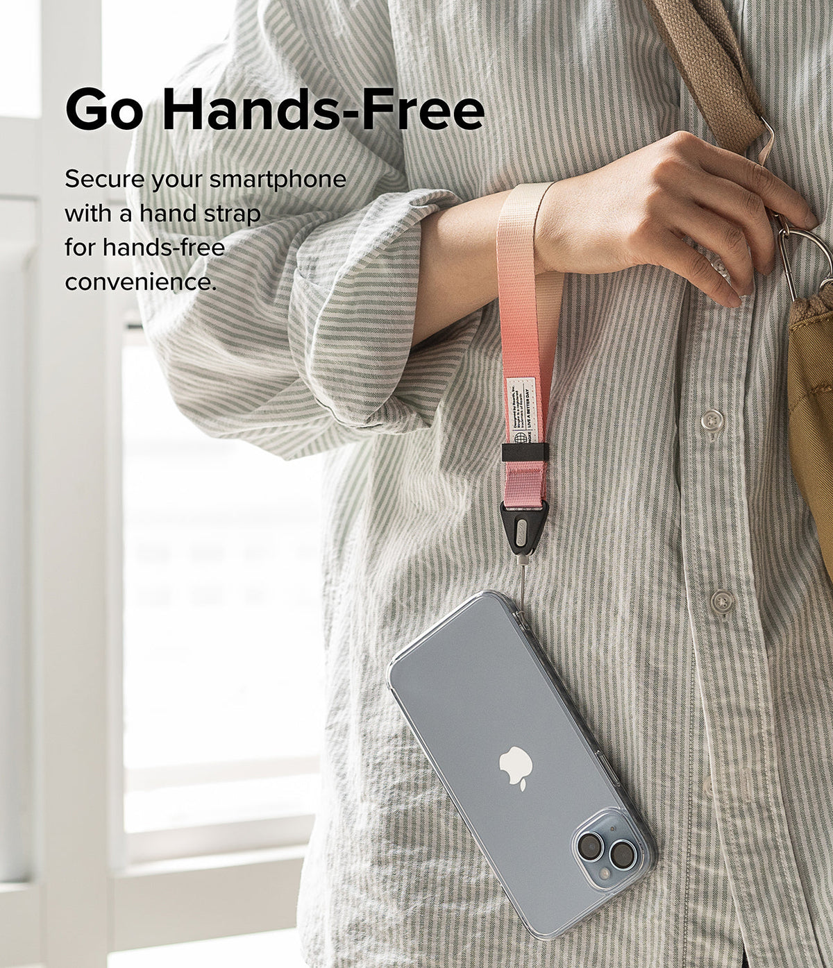 Hand Strap | Basic - A person wearing a pink-to-white gradient wrist strap attached to a smartphone in a clear case.