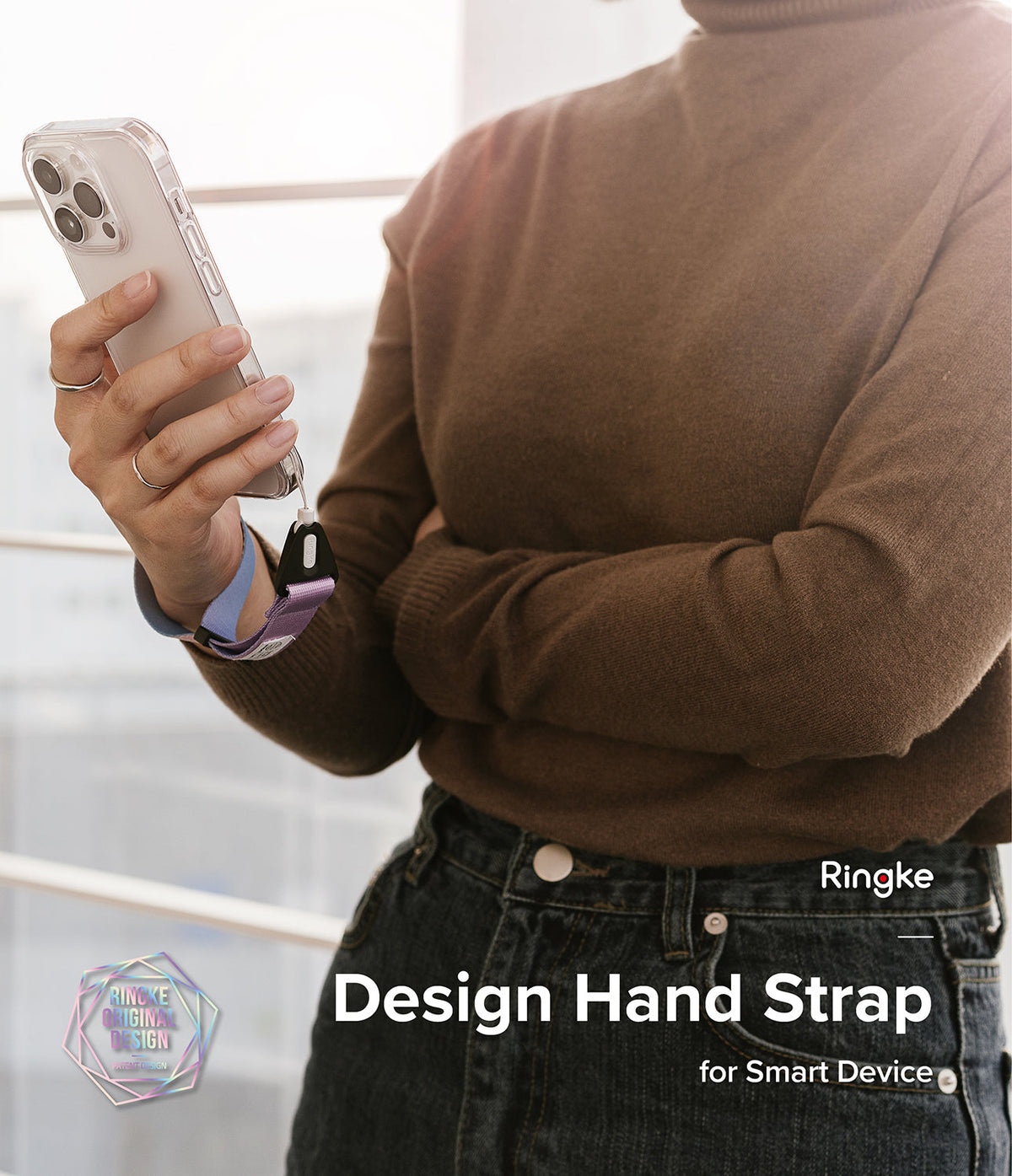 Hand Strap | Basic - Person wearing a brown sweater holds a smartphone secured by a purple fabric wrist strap.