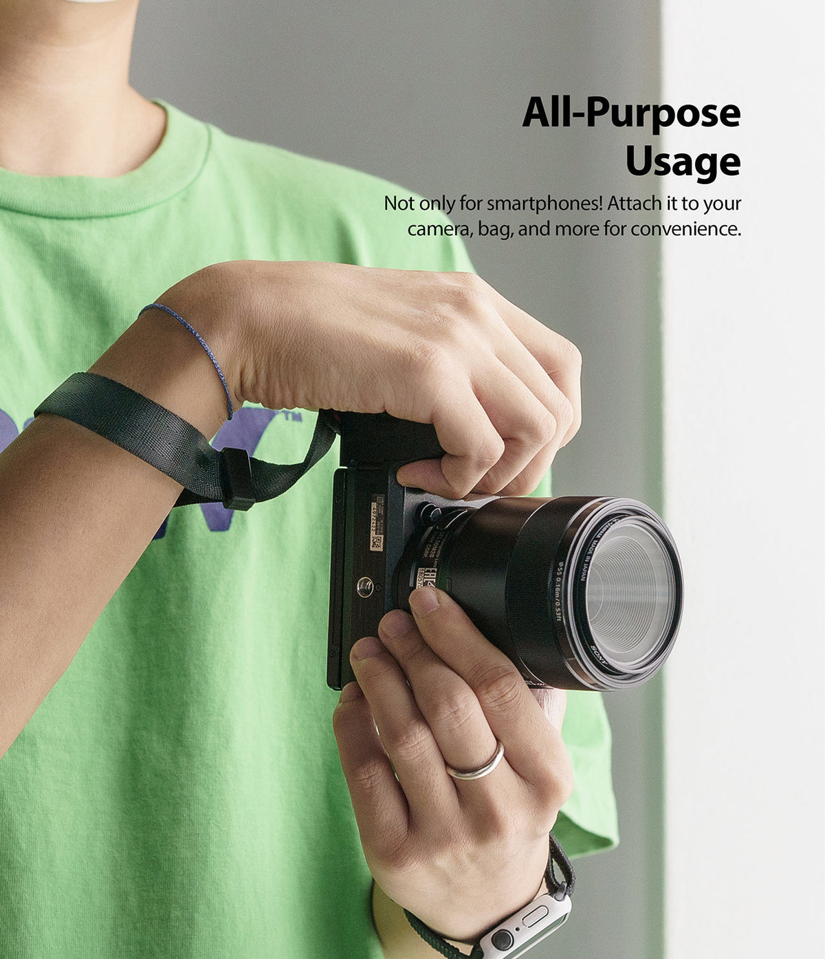 Hand Strap | Black / Neon Orange - Person holding a camera with a black hand strap attached to their wrist.