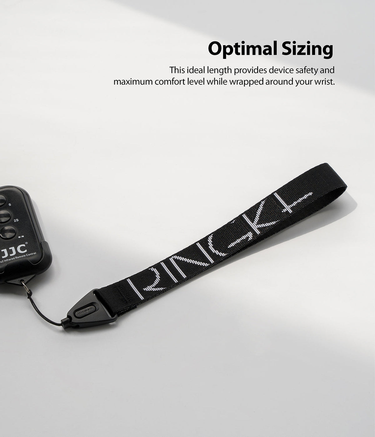 Hand Strap | Lettering - Black wrist strap with white Ringke branding attached to a remote control on a white background.