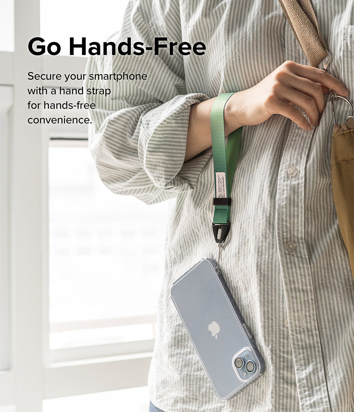 Hand Strap | Basic - A person wearing a green fabric wrist strap attached to a smartphone in a clear case.