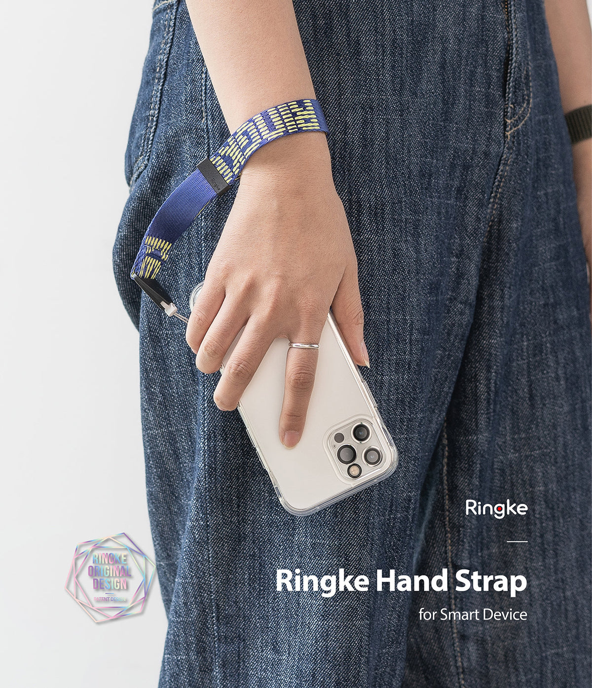 Hand Strap | Lettering - A person wearing a blue and yellow patterned fabric hand strap attached to a smartphone in a clear case.
