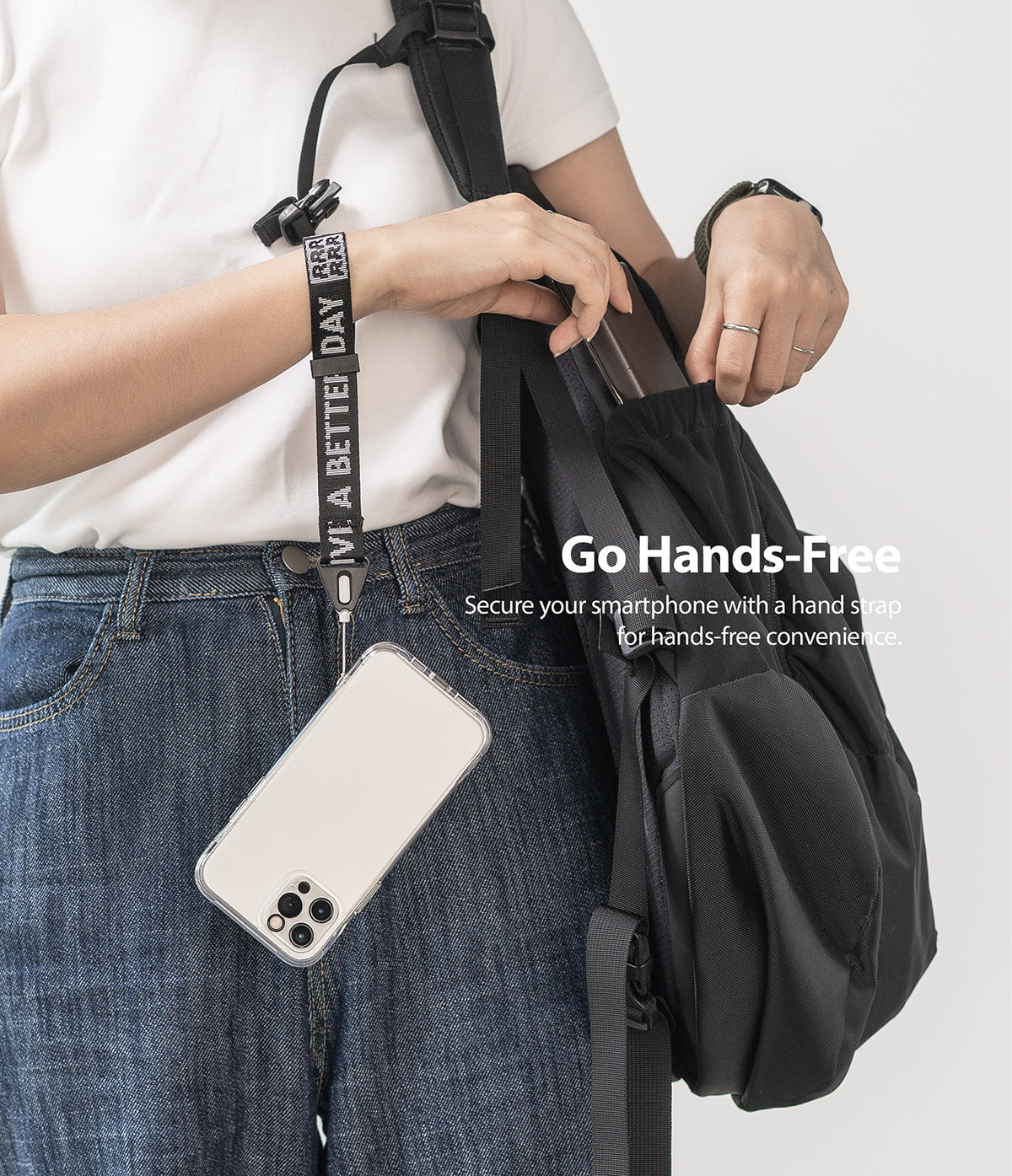 Hand Strap | Lettering - Person wearing a black strap with white lettering attached to a smartphone hanging from their wrist.
