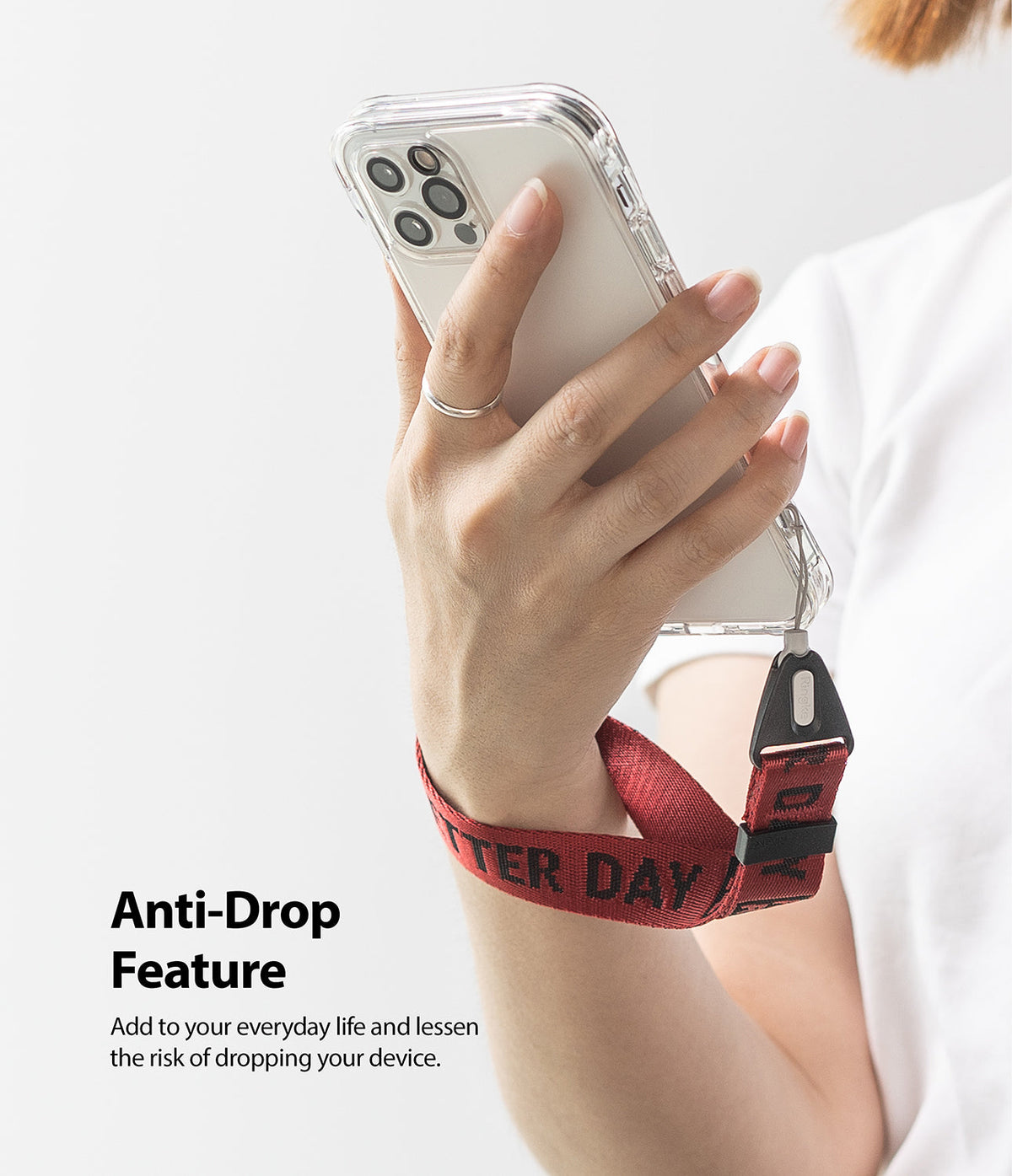 Hand Strap | Lettering - A person holding a phone with a red fabric wrist strap featuring black lettering for anti-drop security.