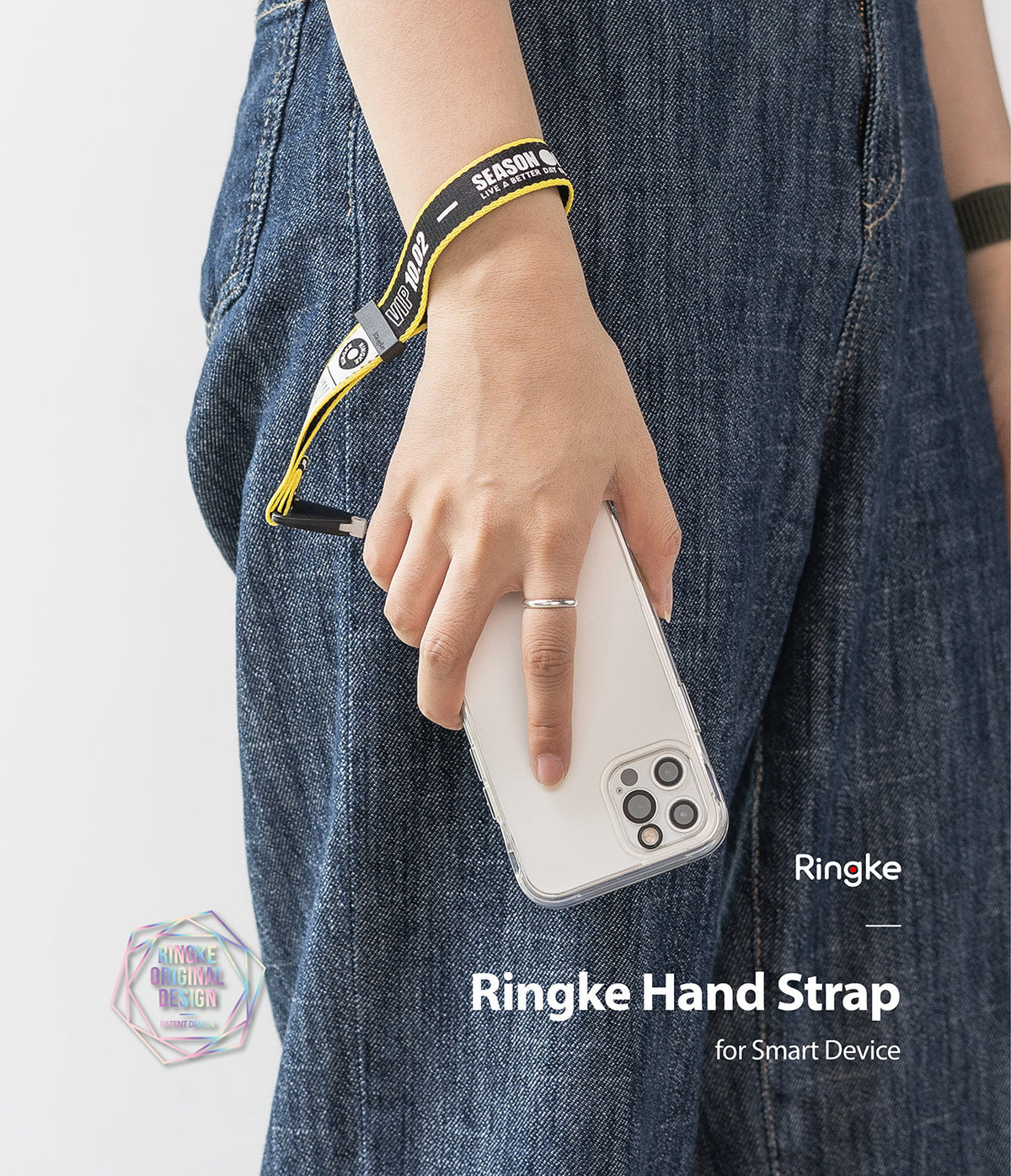 Hand Strap | Lettering - Person wearing a black and yellow branded wrist strap attached to a clear smartphone case.