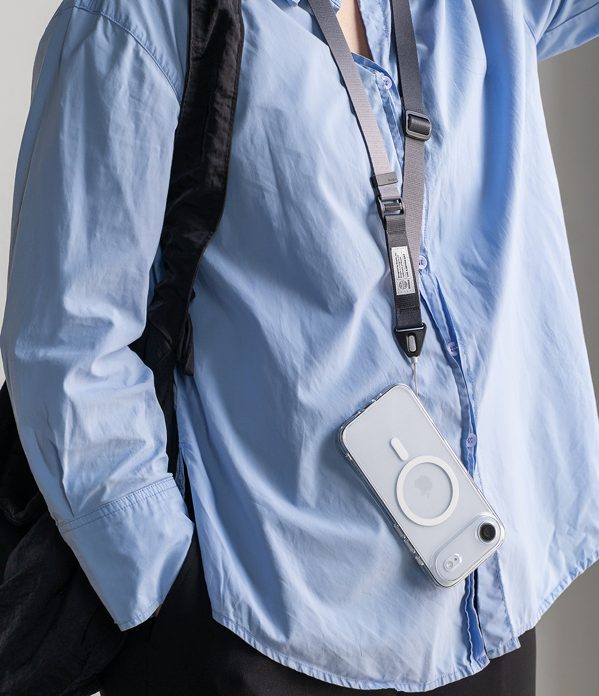 Design Lanyard Strap - A person in a light blue shirt wearing a grey adjustable lanyard attached to a clear phone case.