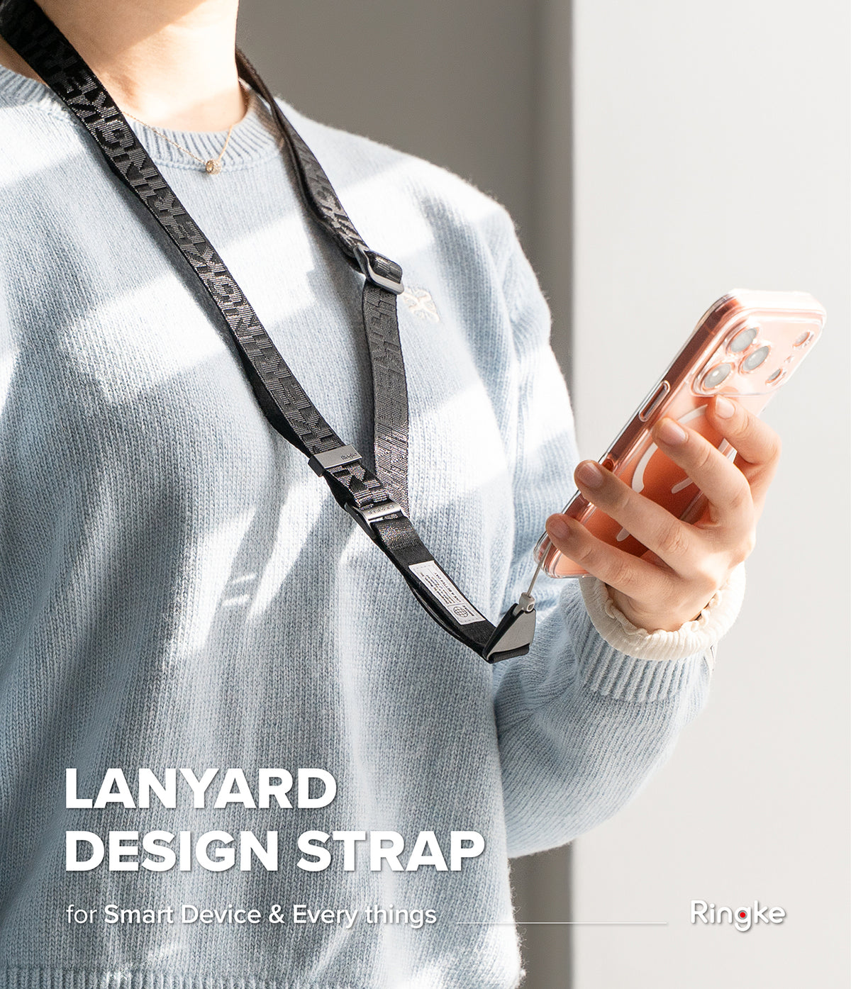 Design Lanyard Strap - Person wearing a black branded lanyard strap connected to a smartphone in a clear case.