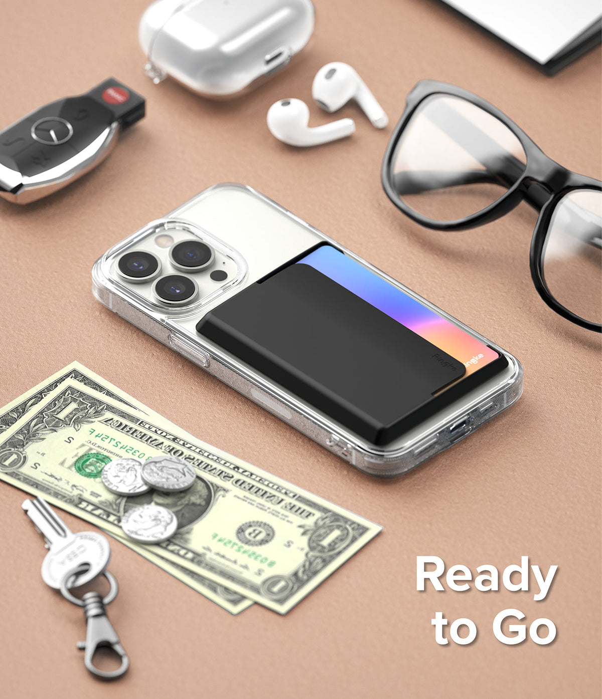 Card Holder | Side Slot - Black card holder attached to a clear phone case, surrounded by daily essentials on a tan surface.
