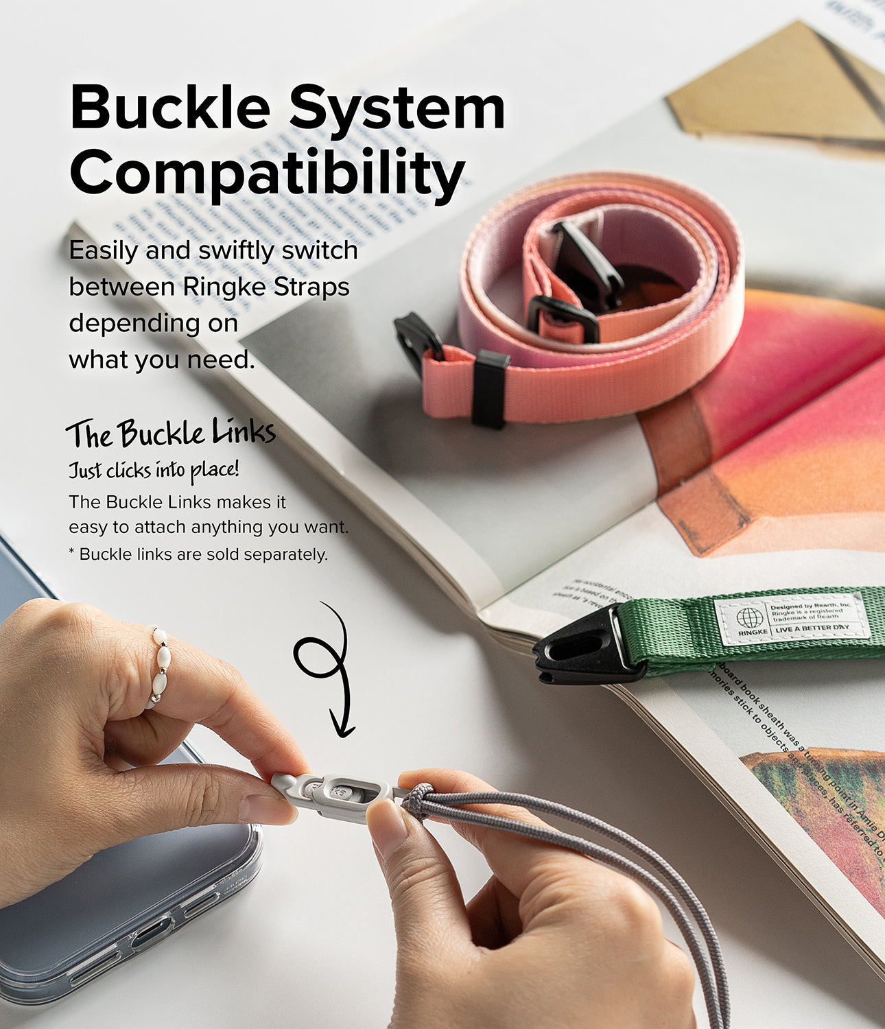 Design Shoulder Strap - Hands connecting a gray buckle link to a phone strap with pink and green straps on a book.