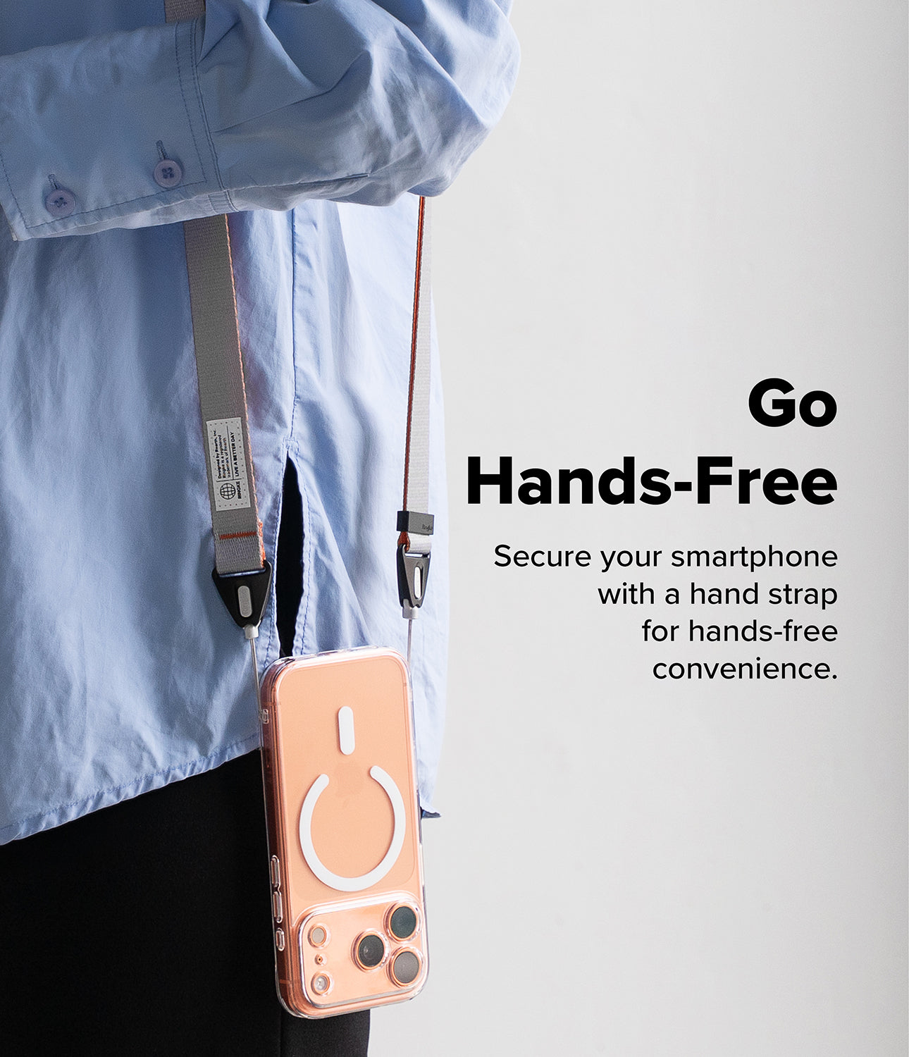 Design Shoulder Strap - A person wearing a light blue shirt with a phone on a grey shoulder strap, with text Go Hands-Free.