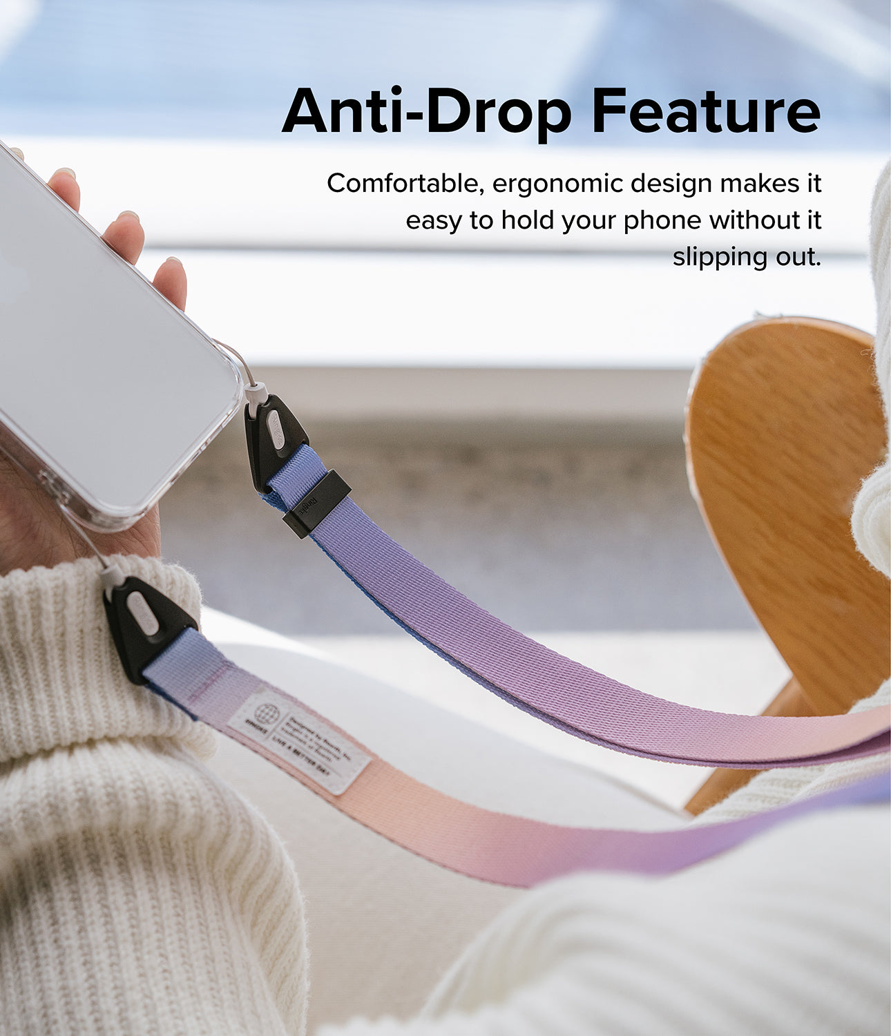 Design Shoulder Strap - A person holding a phone attached to a pastel-colored, gradient fabric shoulder strap.